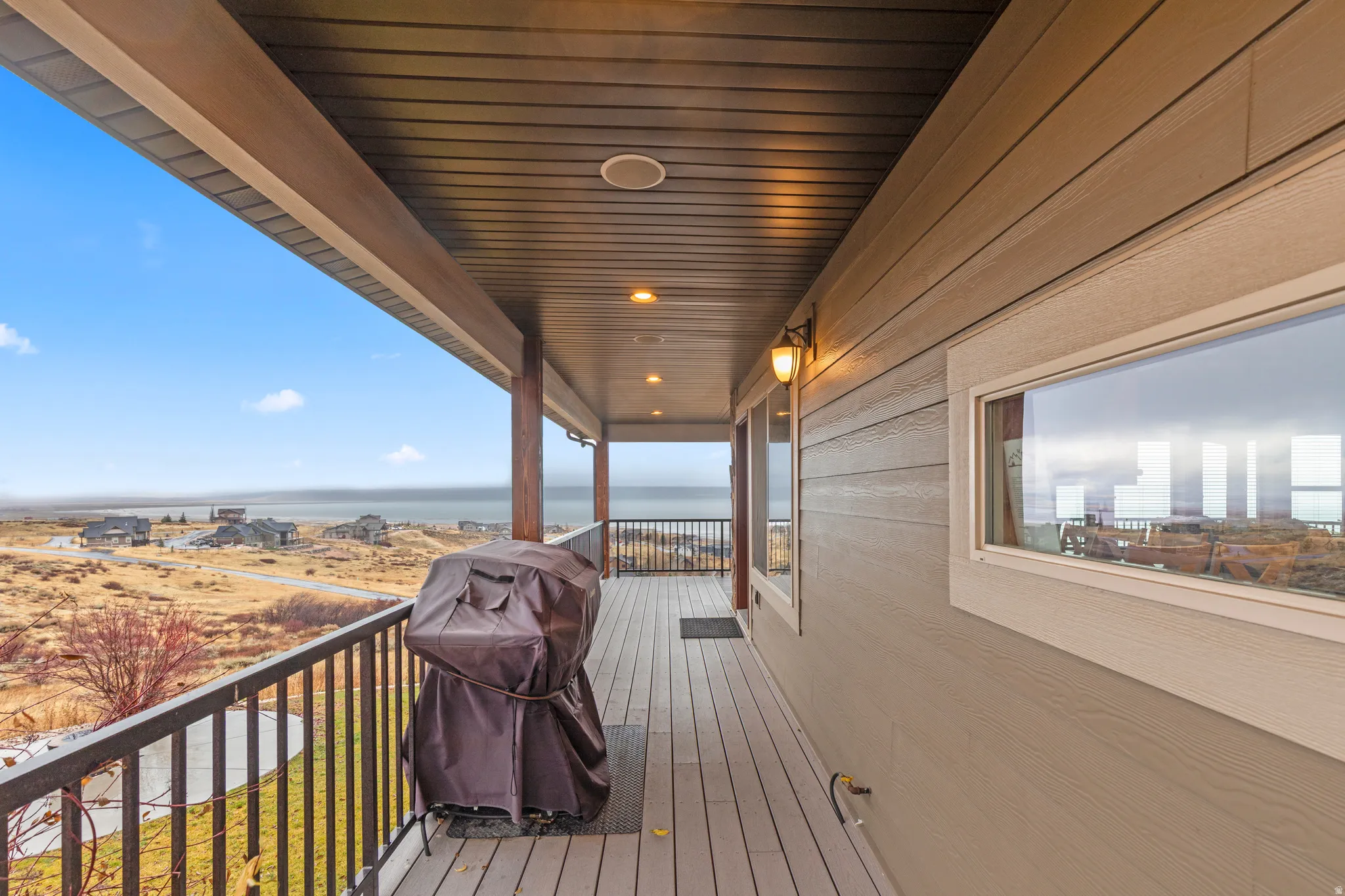 Wooden terrace featuring area for grilling and a water view