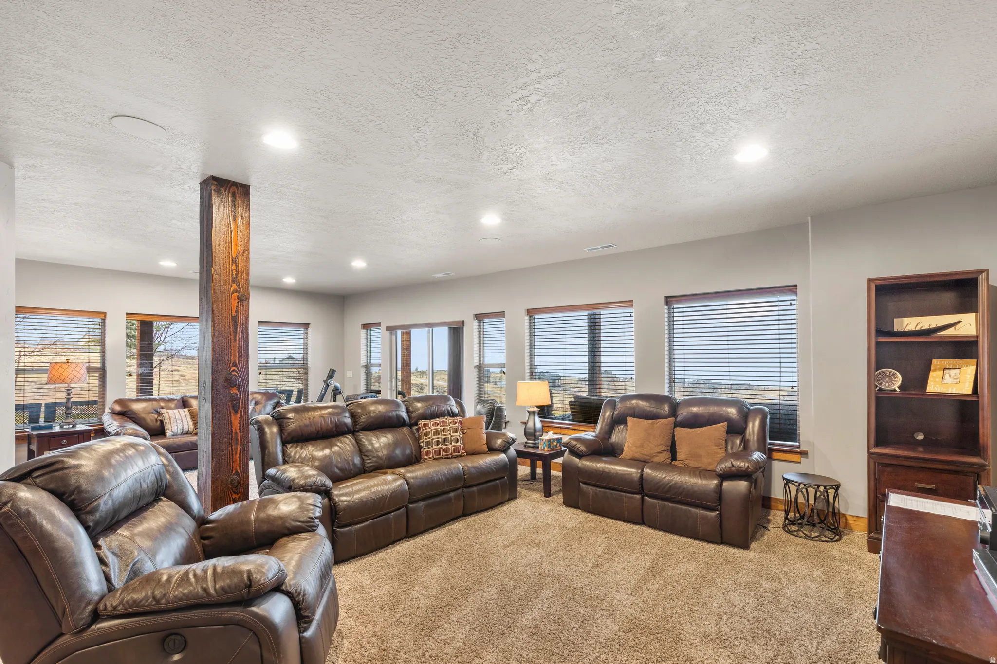 Carpeted living room featuring a textured ceiling and recessed lighting