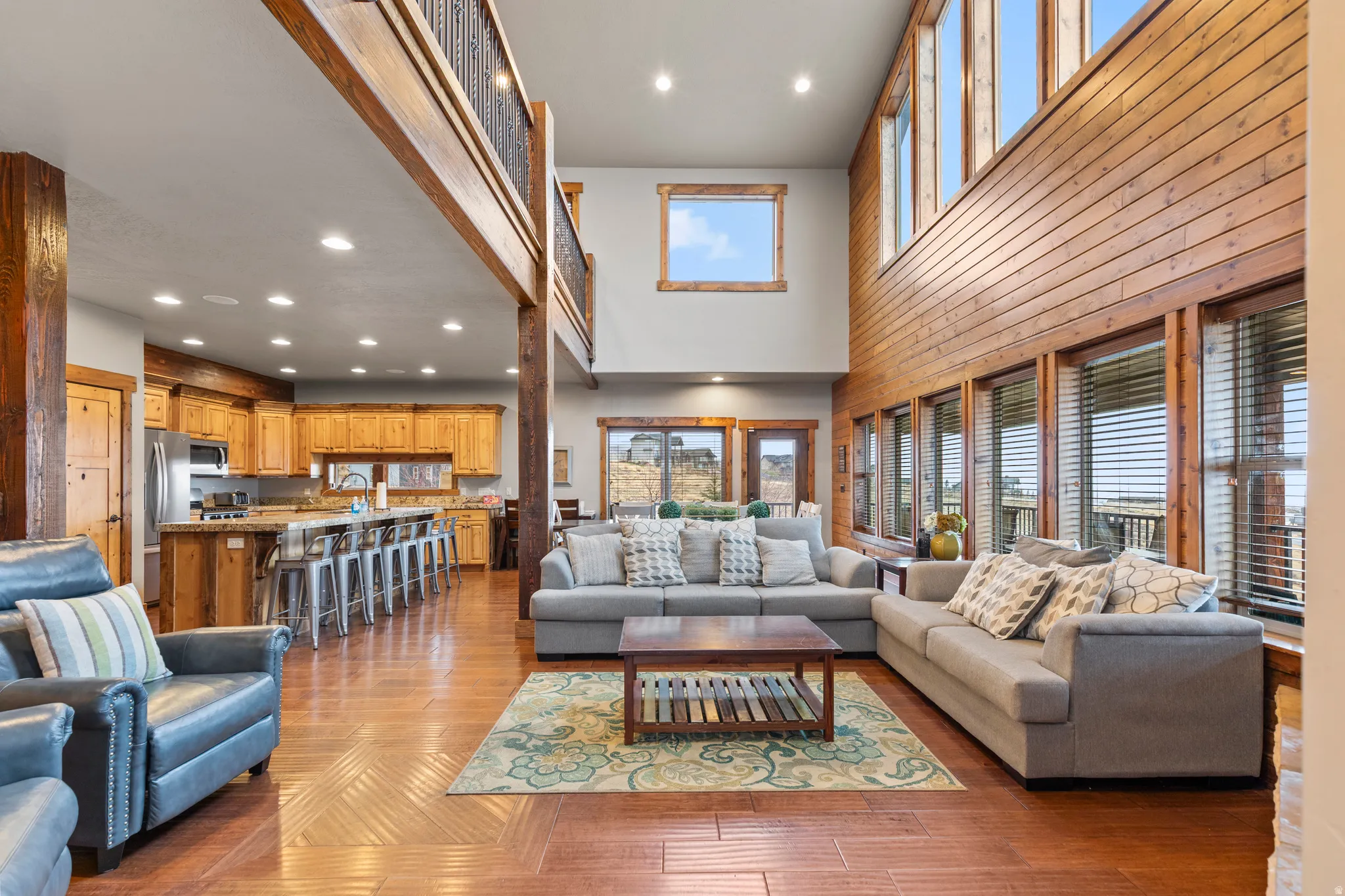 Living area with recessed lighting, light wood finished floors, and a high ceiling