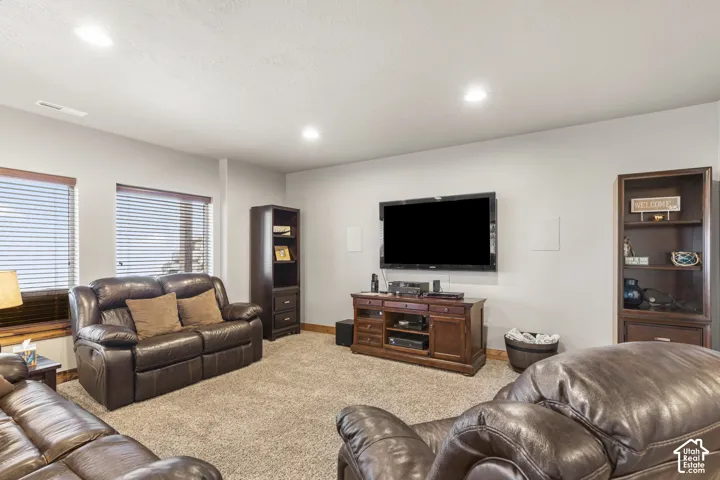 Living area with light colored carpet and recessed lighting