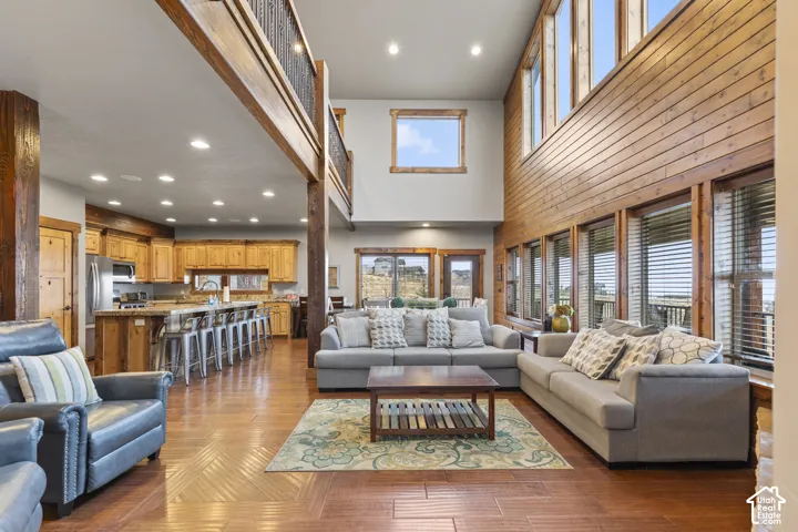 Living area with recessed lighting, light wood finished floors, and a high ceiling