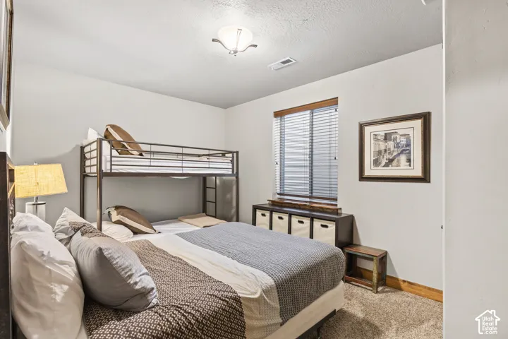 Bedroom featuring carpet floors and a textured ceiling