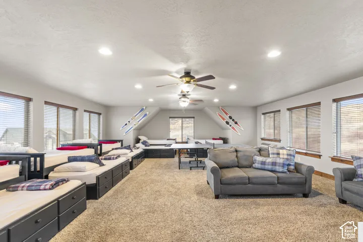 Living room featuring light colored carpet, recessed lighting, a textured ceiling, and ceiling fan