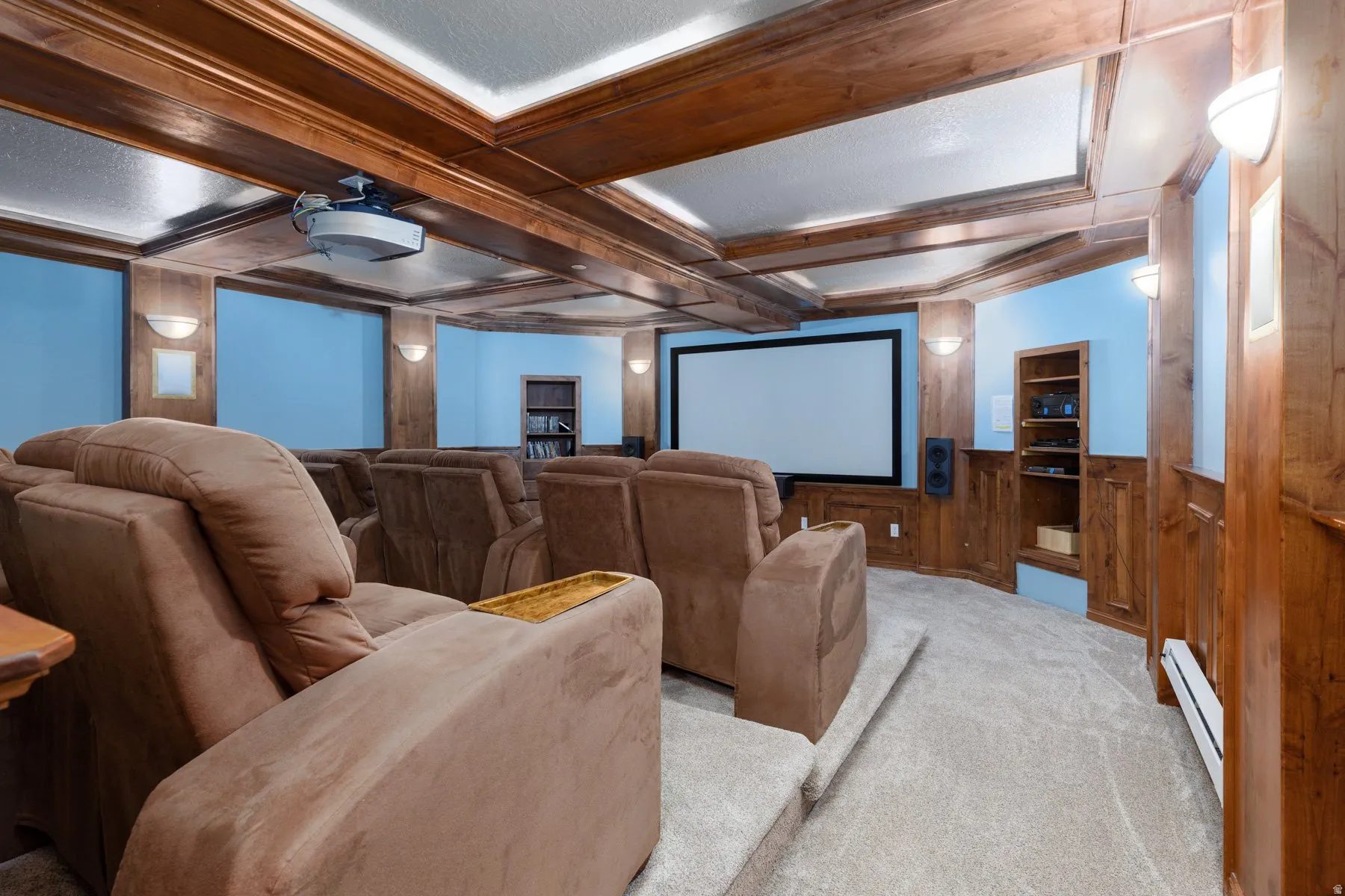 Home theater featuring coffered ceiling, carpet flooring, beam ceiling, a baseboard heating unit, and a wainscoted wall