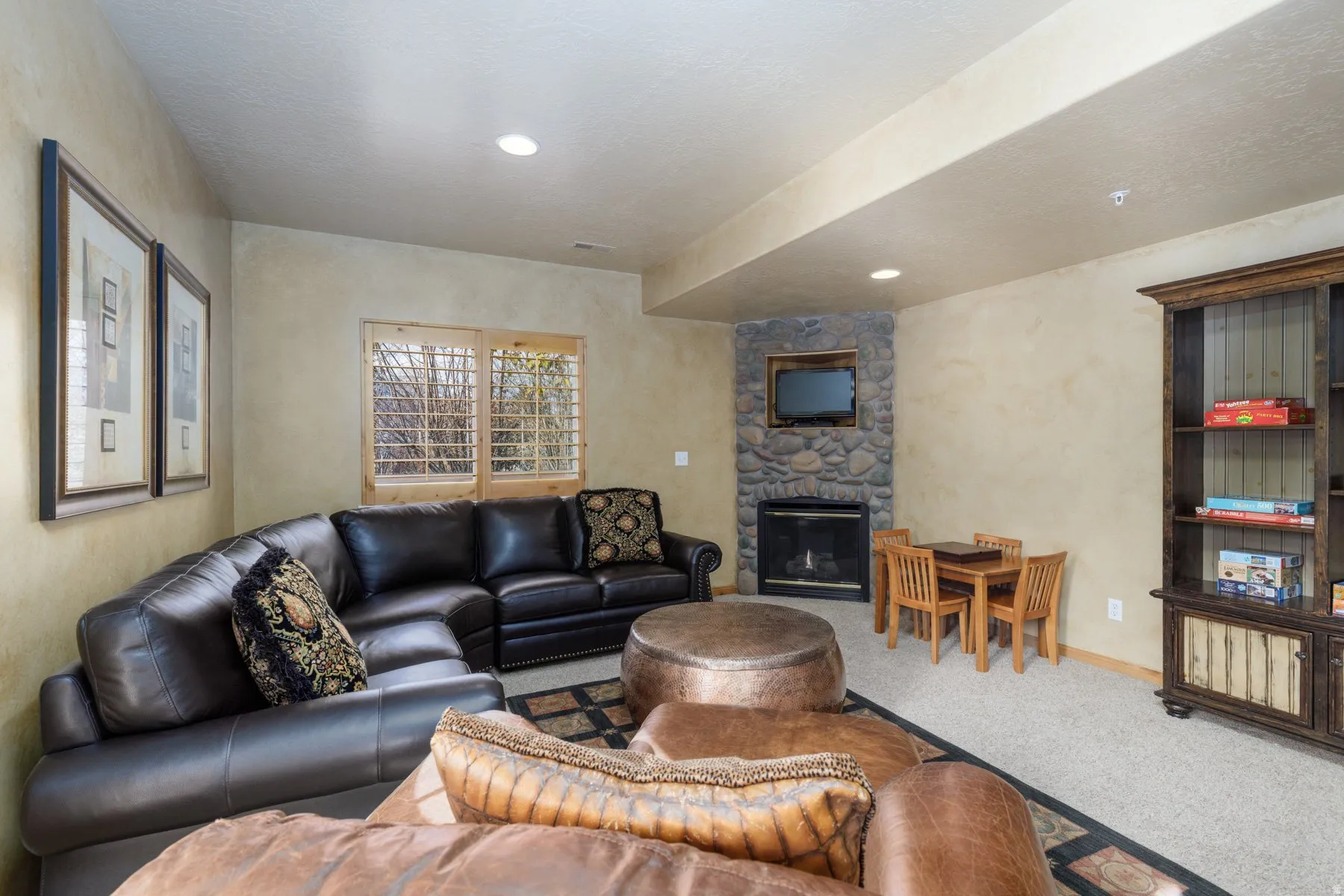 Living area with a stone fireplace, carpet floors, and a textured ceiling
