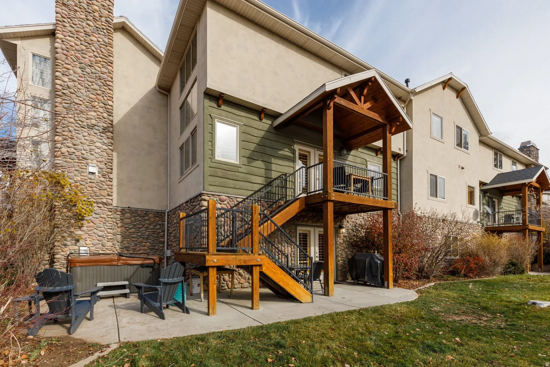 Back of property with a patio area, stairs, stucco siding, and a yard