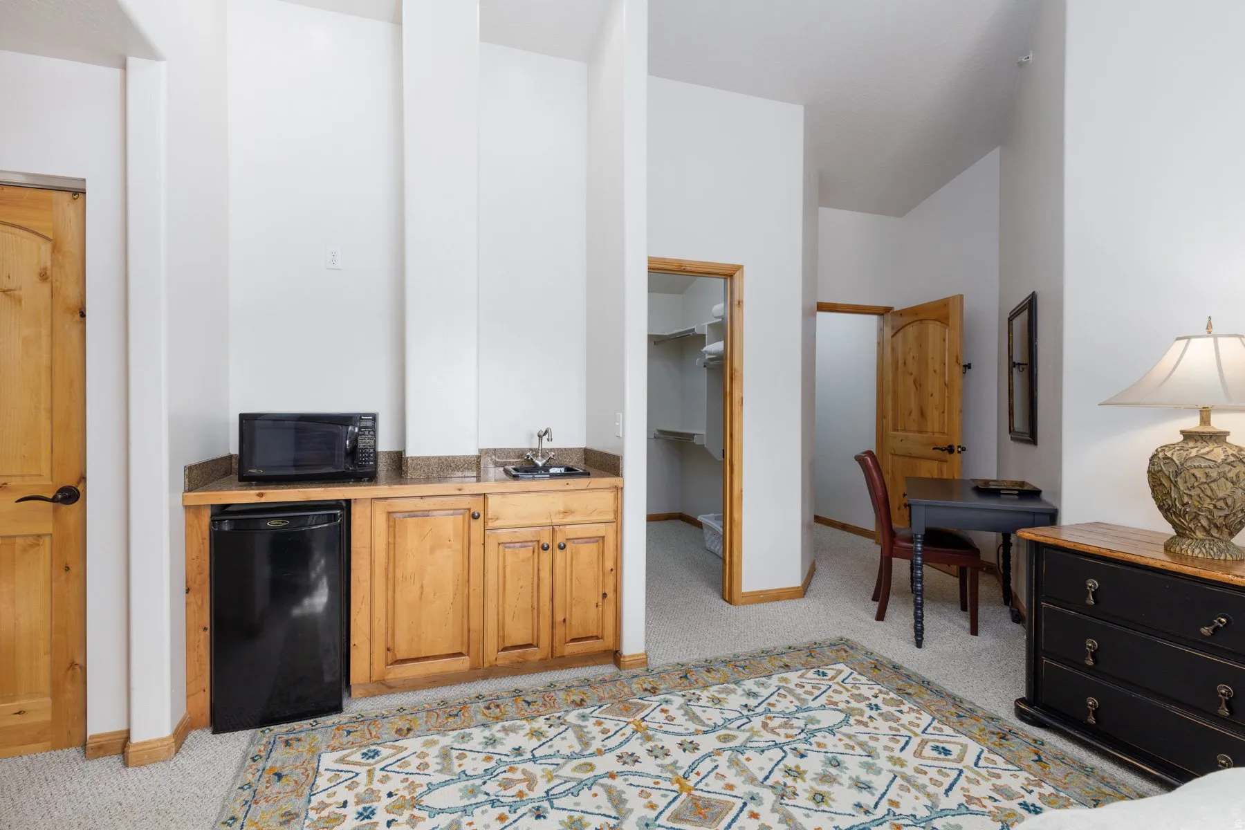 Kitchen featuring light colored carpet and black appliances