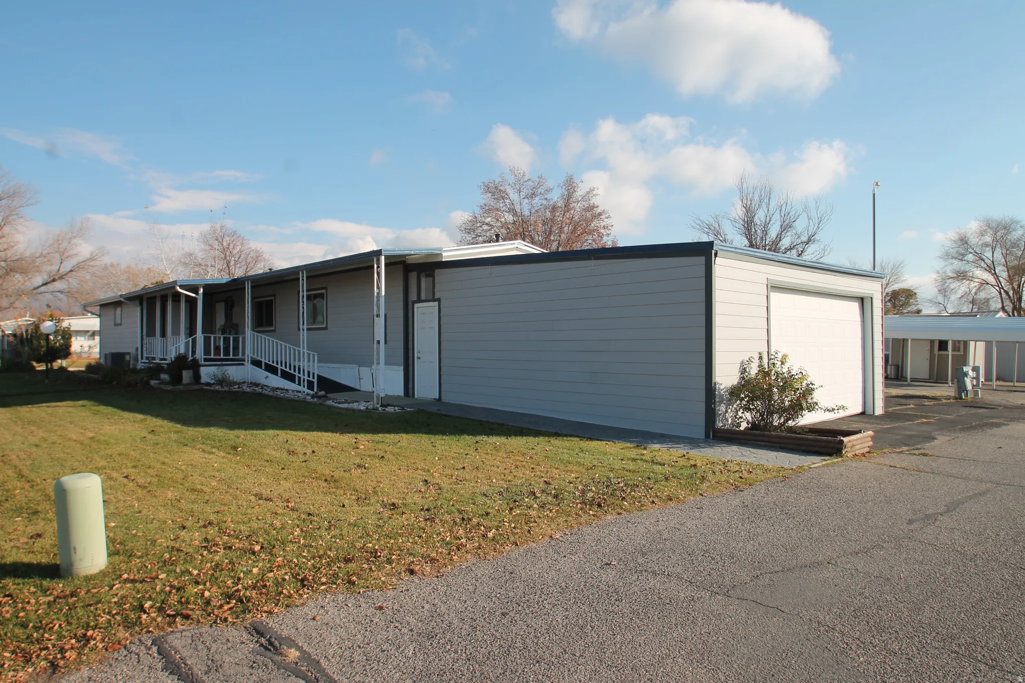 View of front of house featuring a garage, a front yard, and a porch