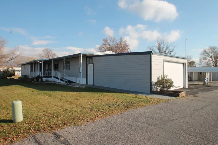 View of front of house featuring a garage, a front yard, and a porch