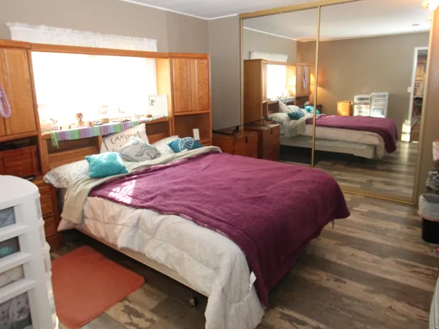 Bedroom featuring dark wood-style floors and a closet