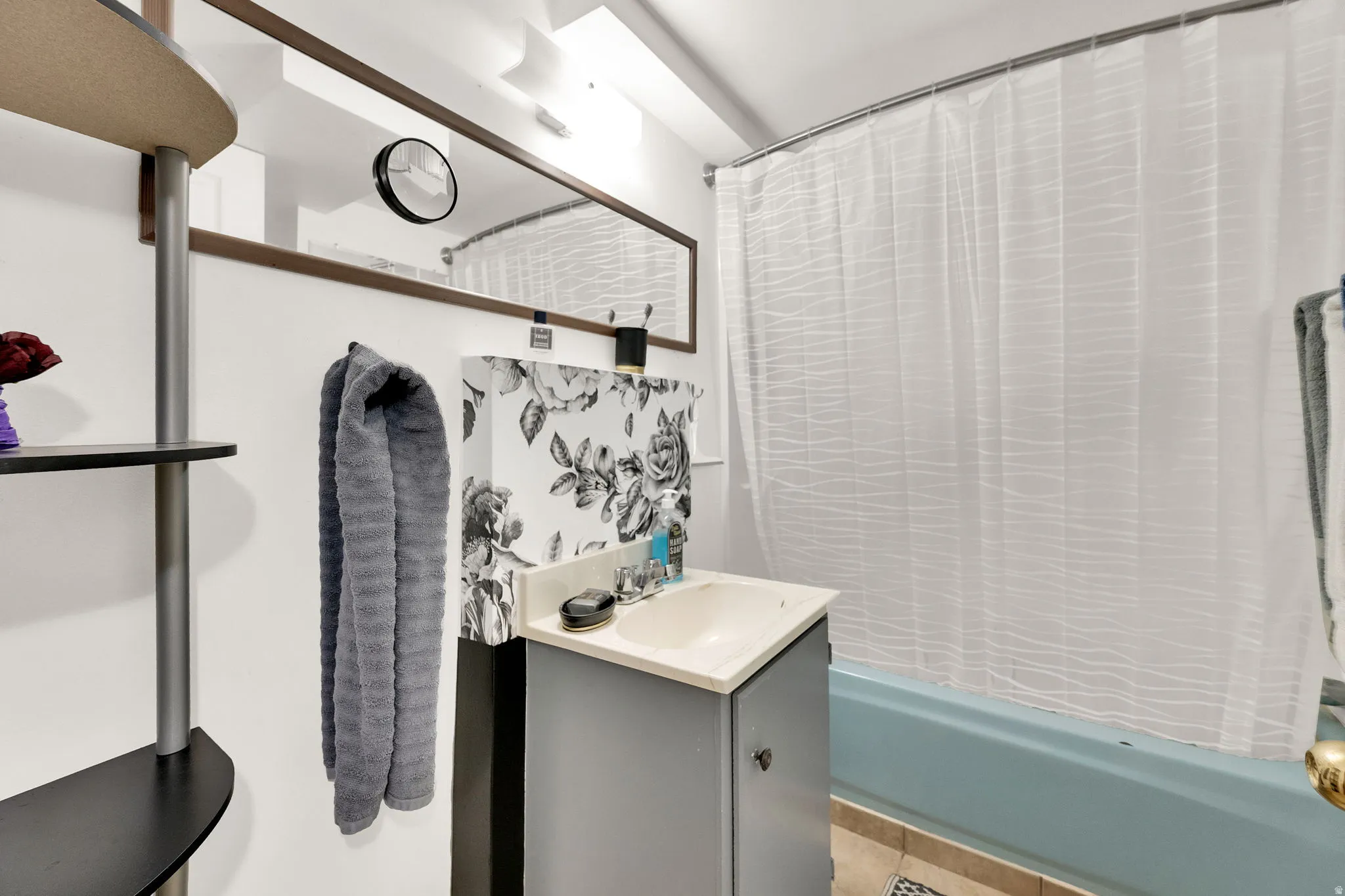 Bathroom featuring vanity and shower / bath combination with curtain
