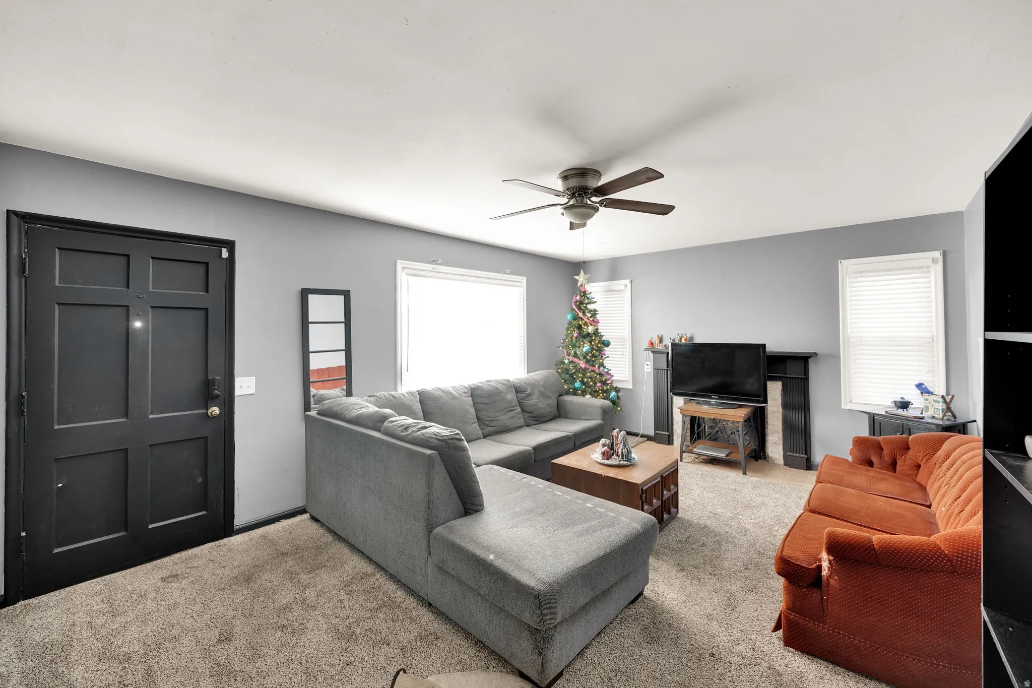 Carpeted living area with ceiling fan
