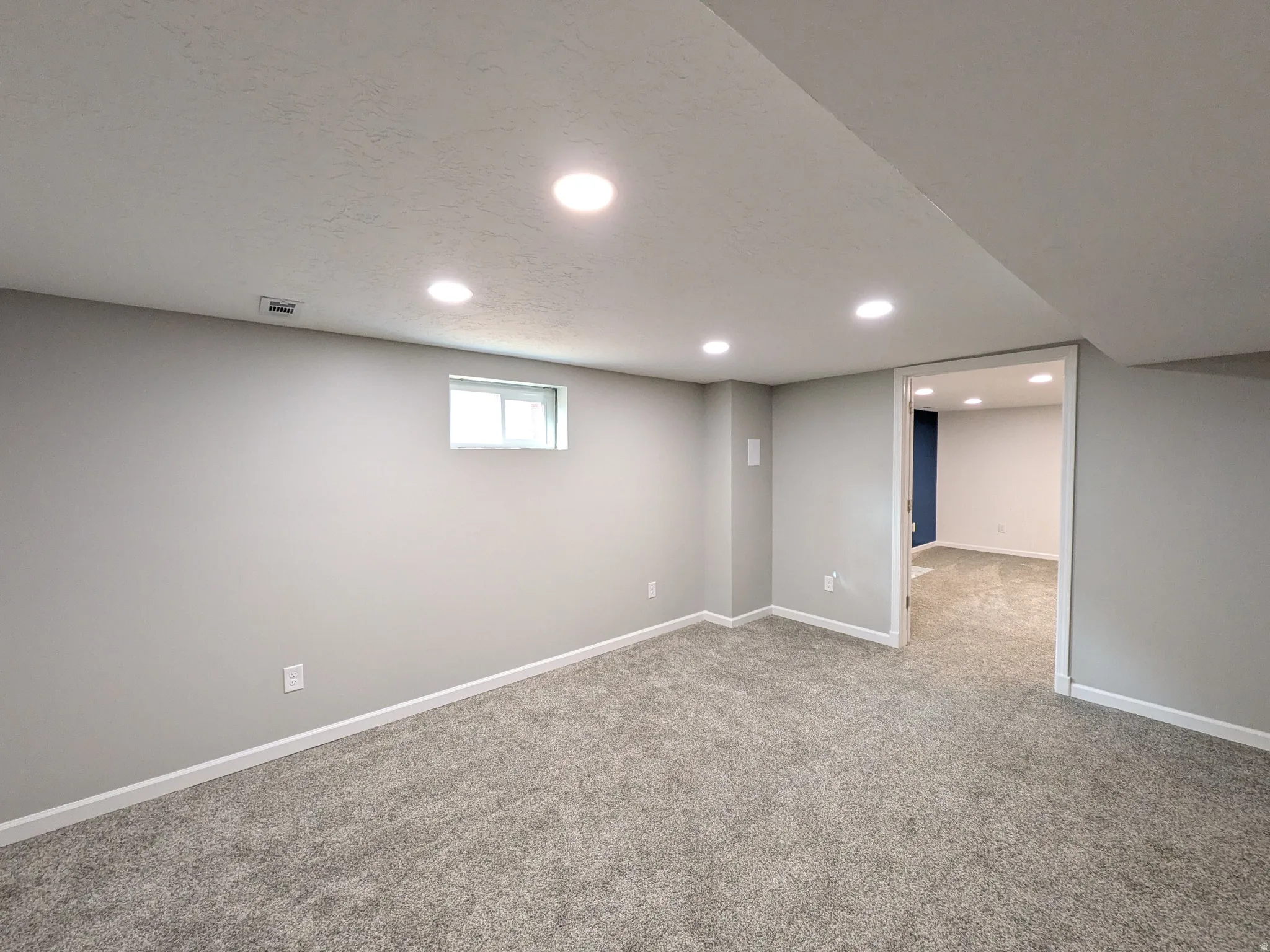 Basement with recessed lighting, carpet flooring, and a textured ceiling