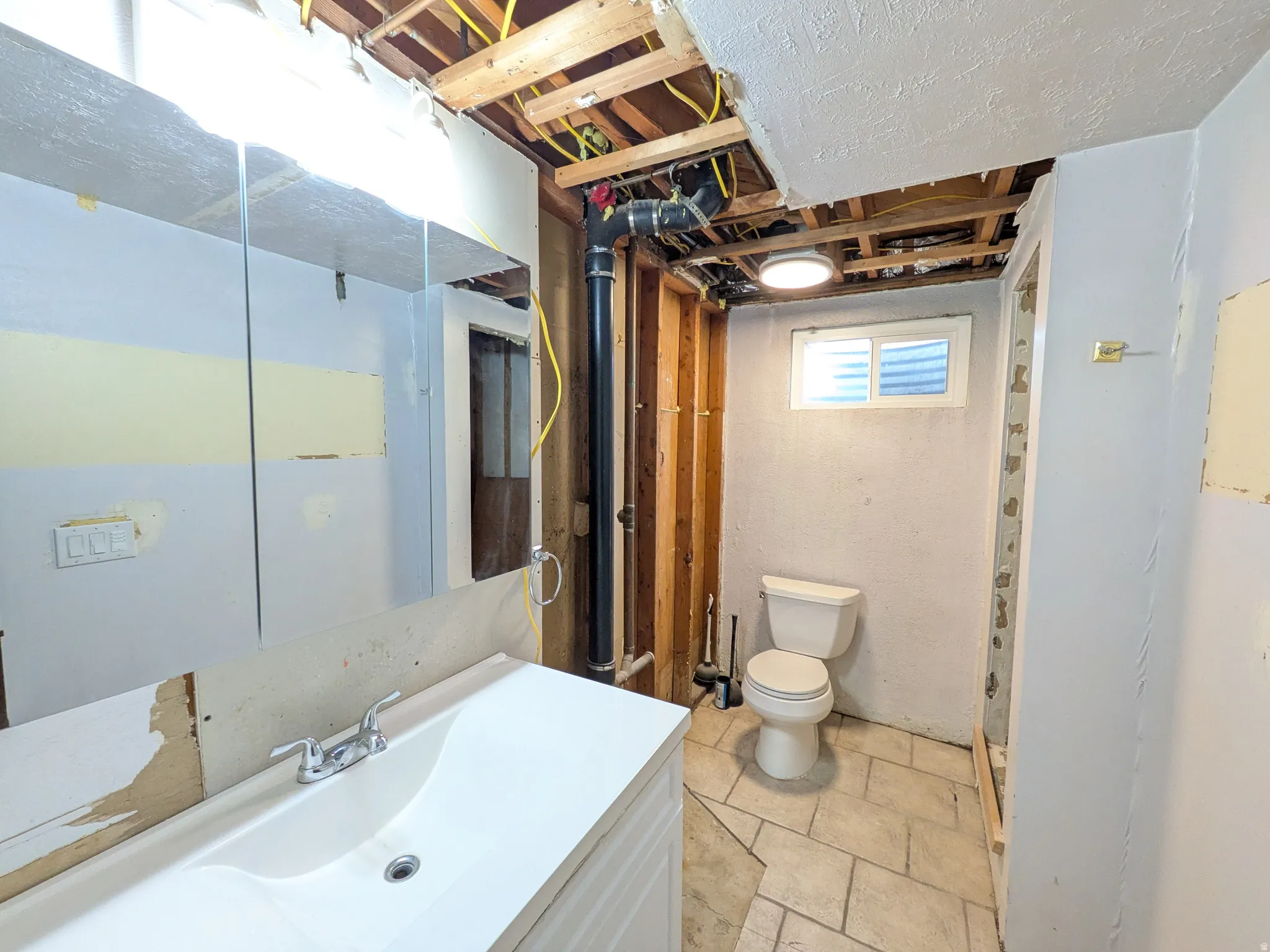Unfinished Bathroom with toilet and vanity