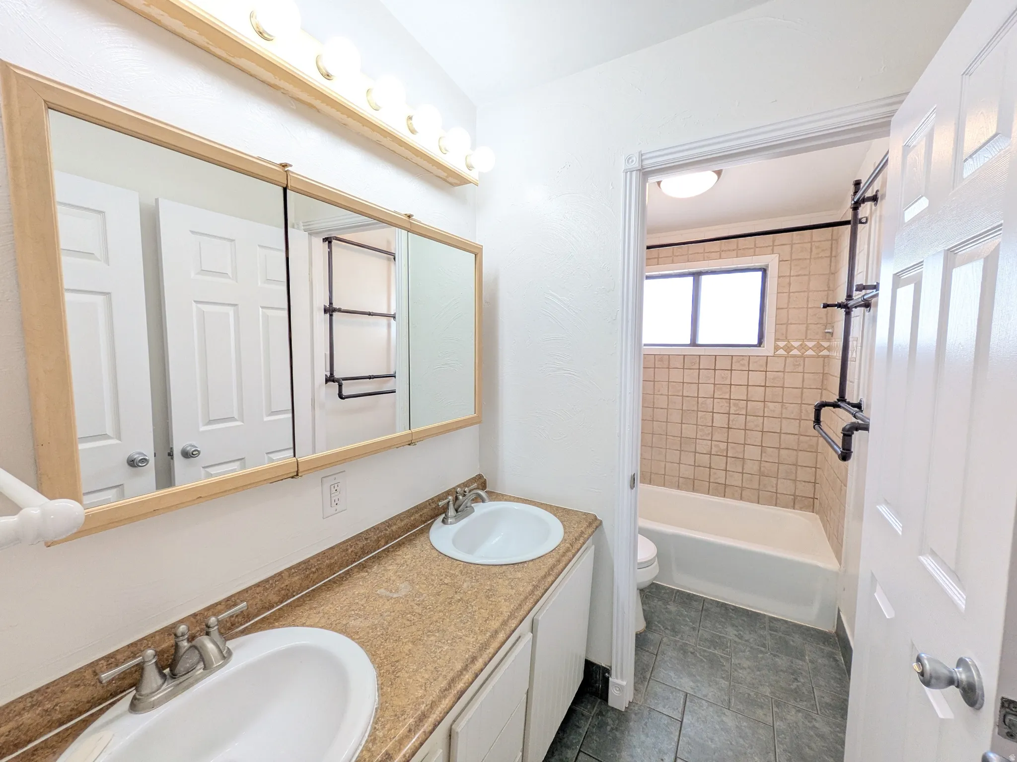 Bathroom with double vanity and shower / tub combination