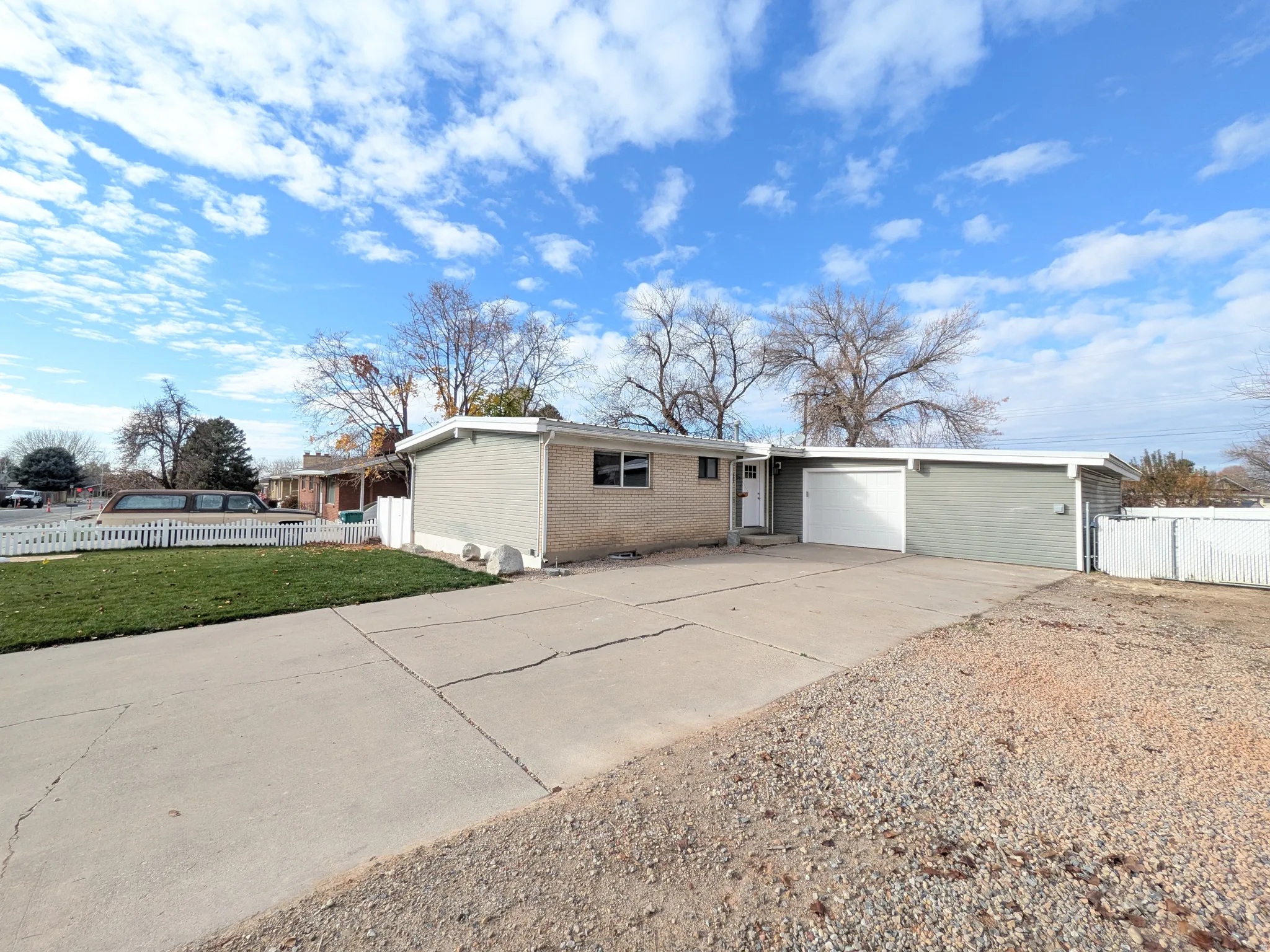 View of front of house with concrete driveway, brick siding, and an attached garage