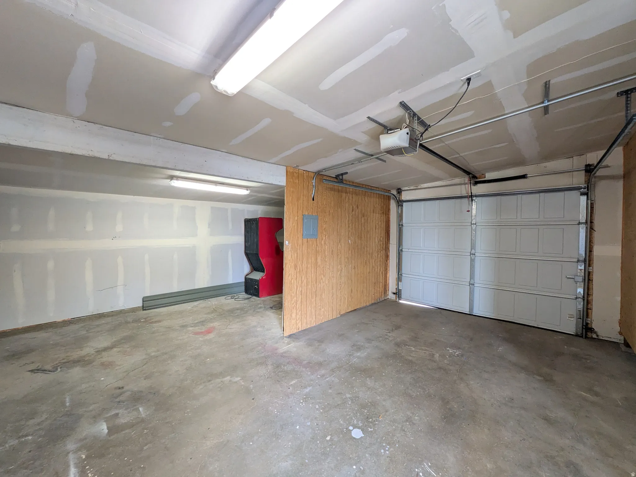 Garage featuring a garage door opener and electric panel