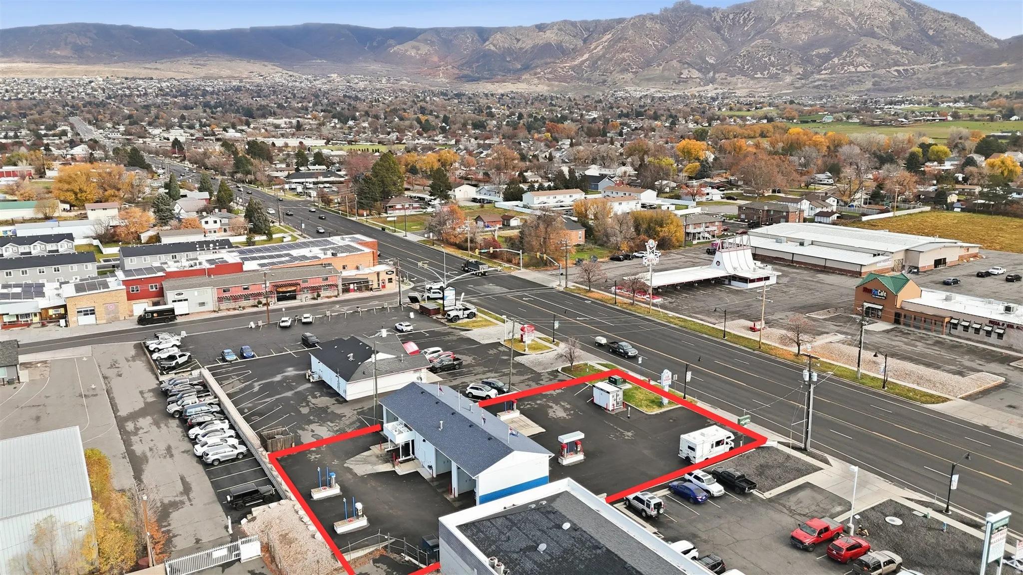 Aerial view of property and surrounding area with a mountain backdrop and property boundaries highlighted