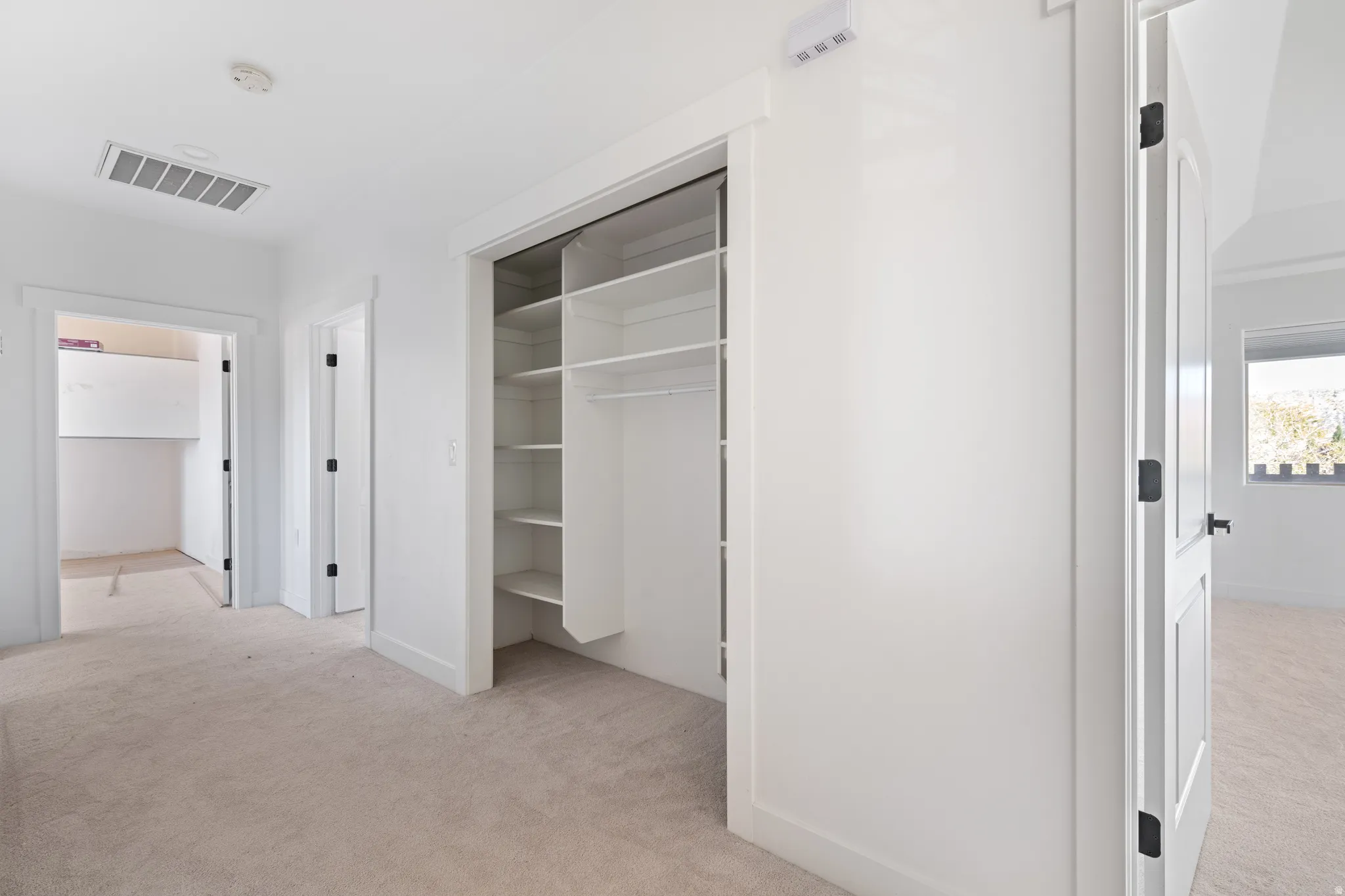 Unfurnished bedroom with light colored carpet and a closet