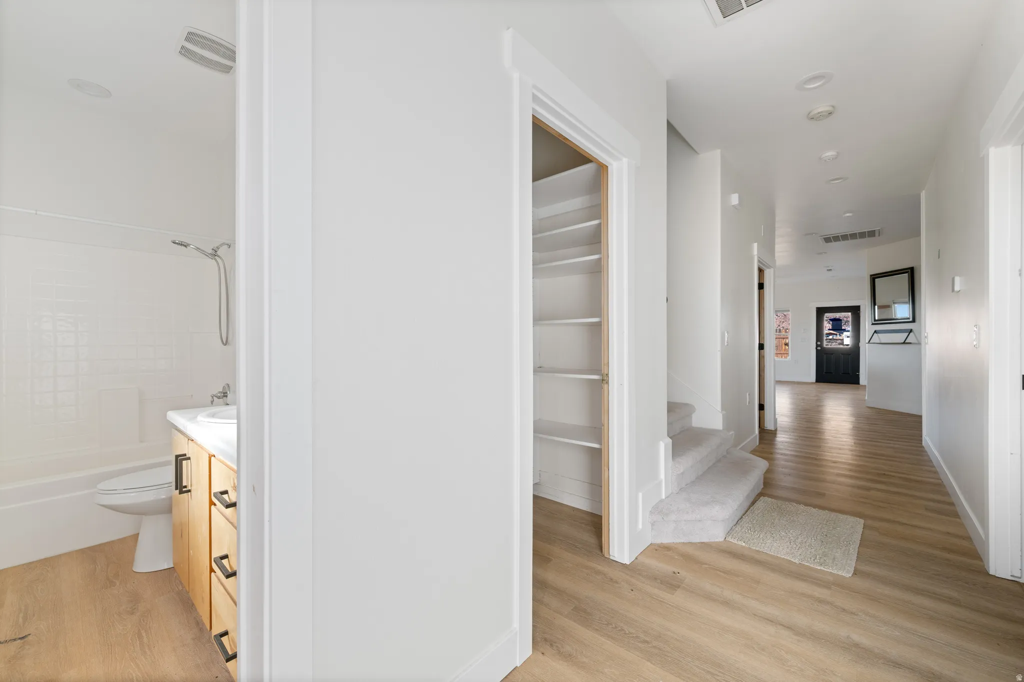 Corridor featuring light wood-type flooring and baseboards