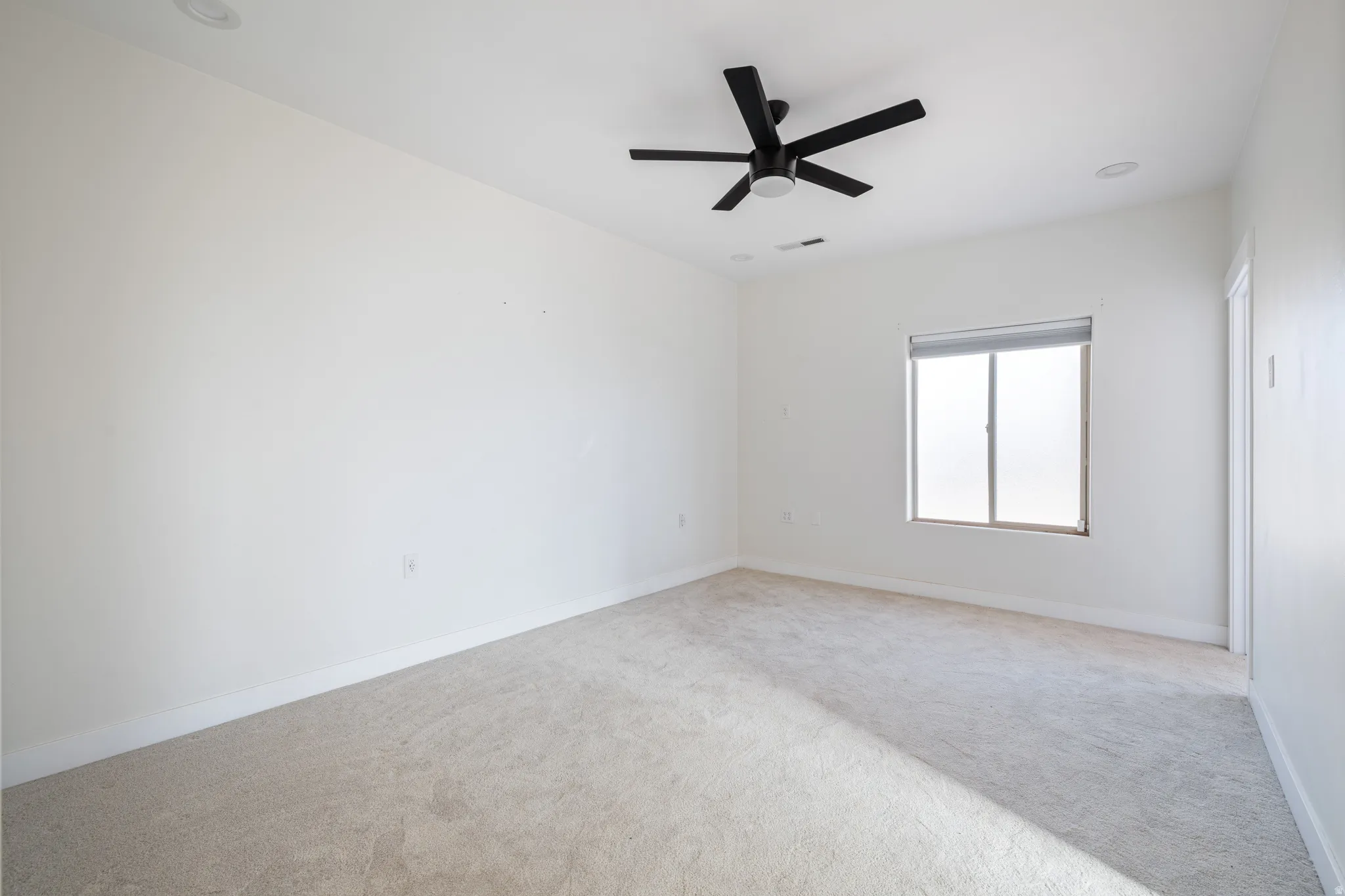 Spare room with light colored carpet and ceiling fan