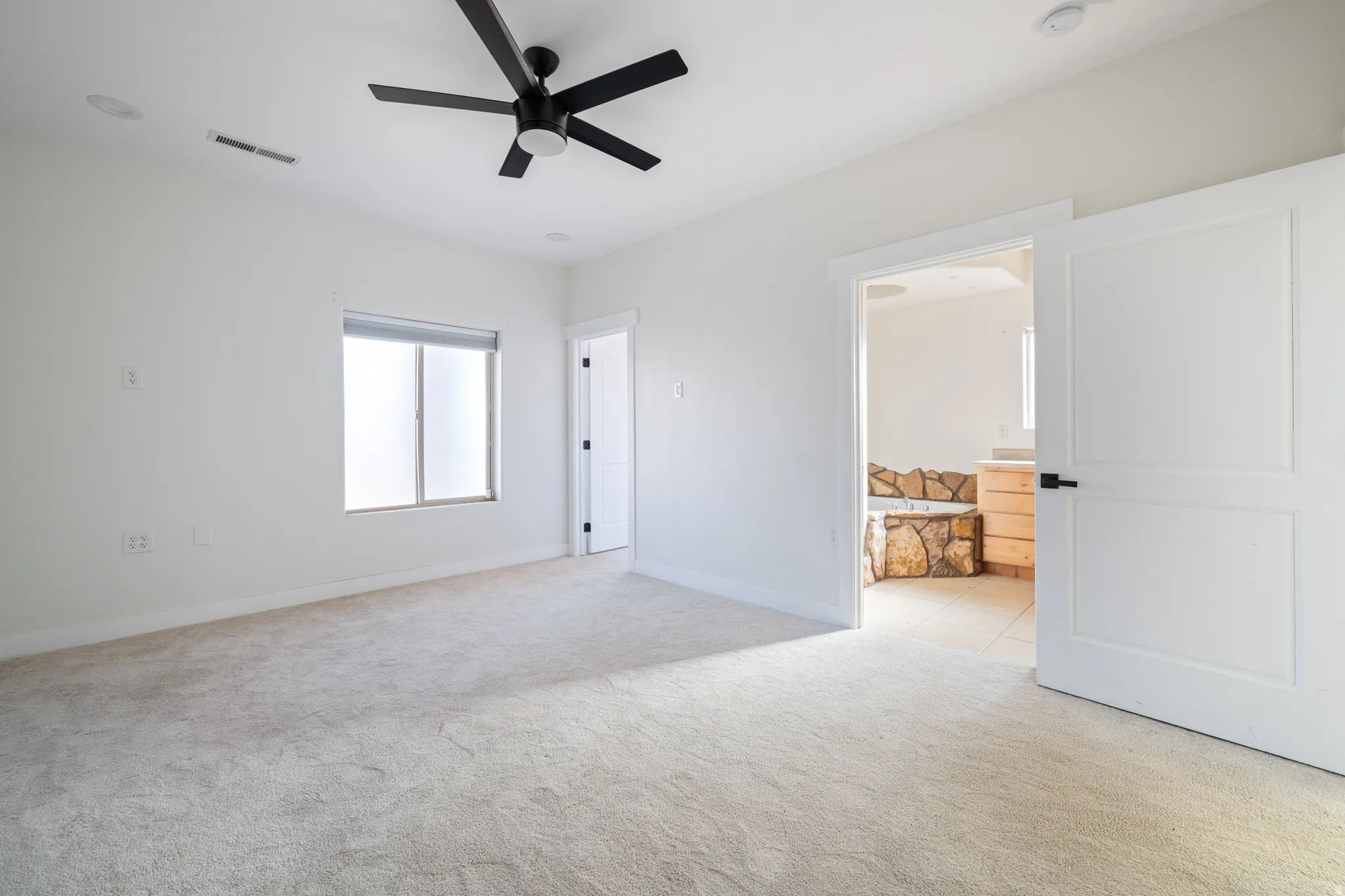 Unfurnished room with light carpet and a ceiling fan