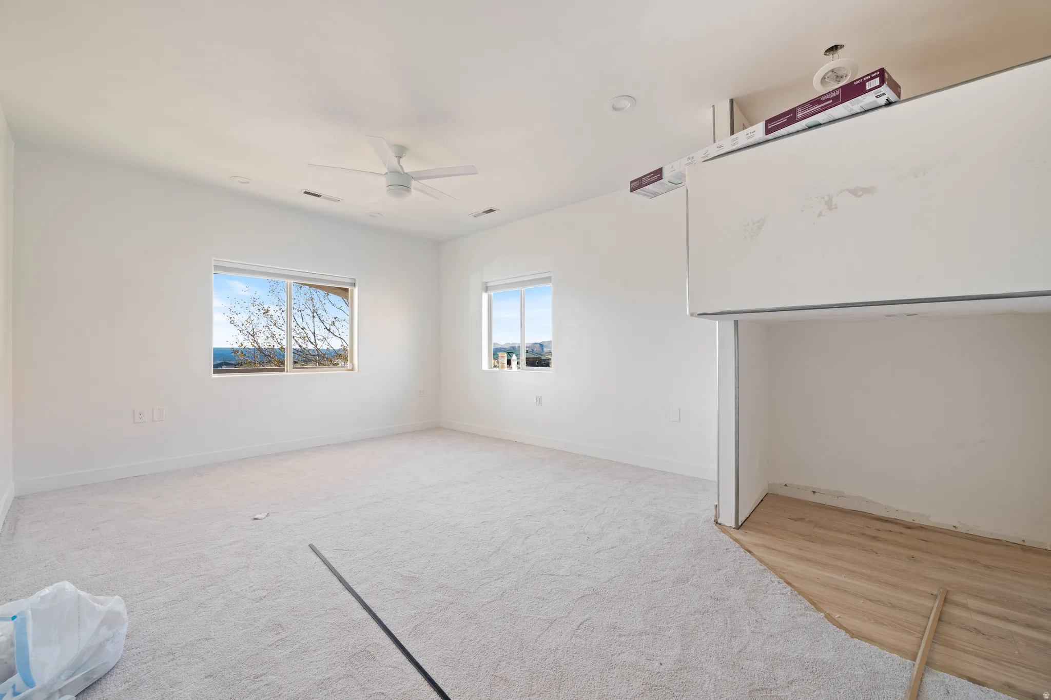 Empty room featuring ceiling fan and light carpet
