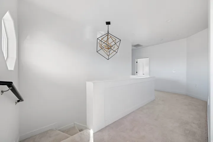 Stairs featuring carpet floors and a chandelier