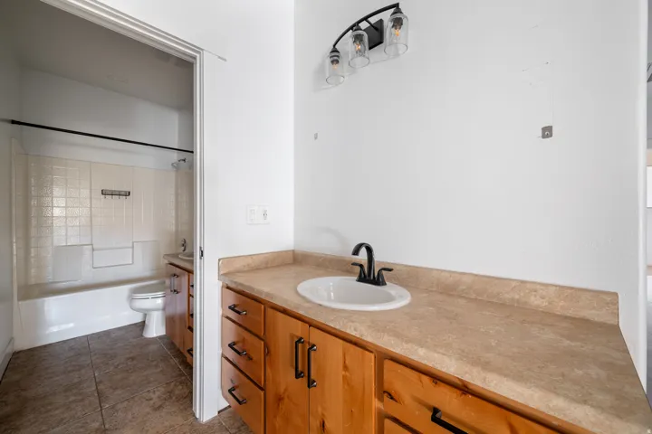 Bathroom featuring vanity, dark tile patterned floors, and bathtub / shower combination