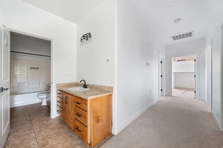 Bathroom with vanity,  shower combination, light carpet, and light tile patterned floors