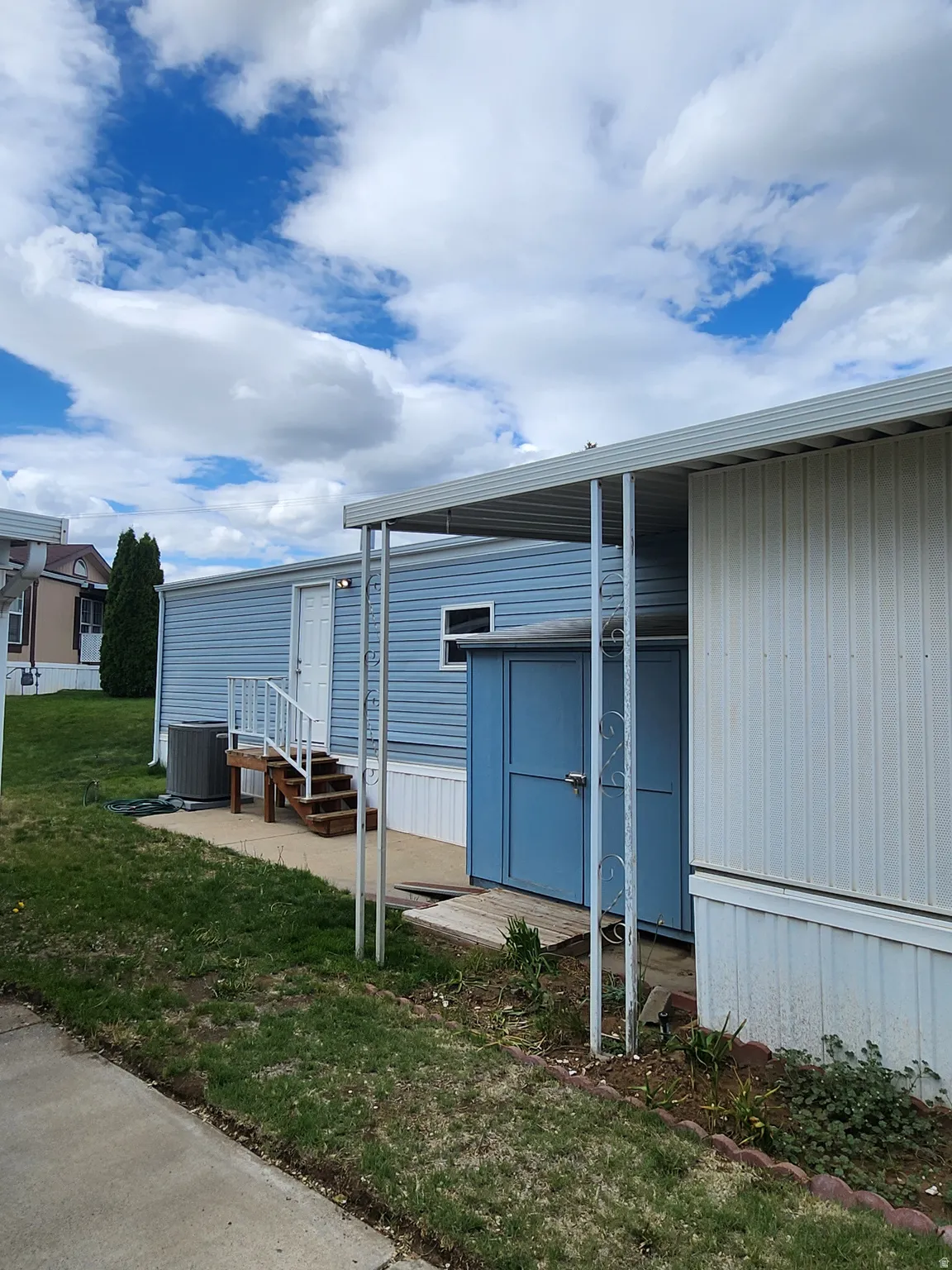View of home's exterior with entry steps and a yard