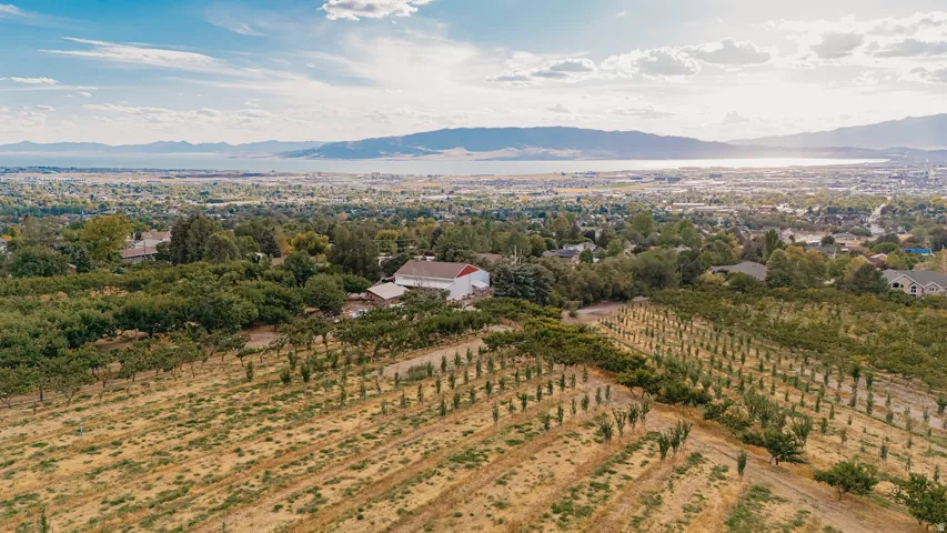 Aerial view of sparsely populated area featuring a mountainous background and extensive farmland