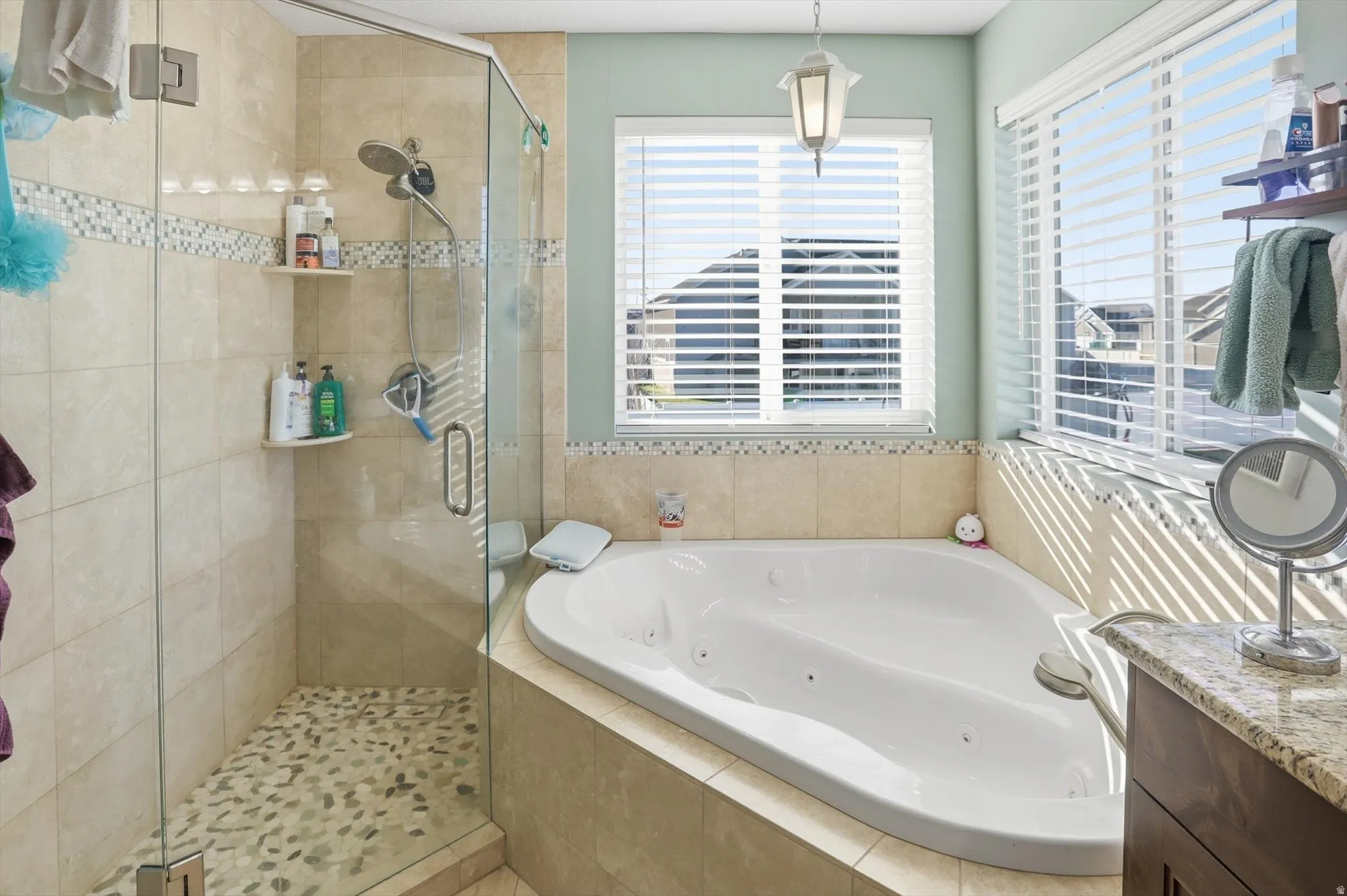 Full bath featuring a tub with jets, a shower stall, and vanity