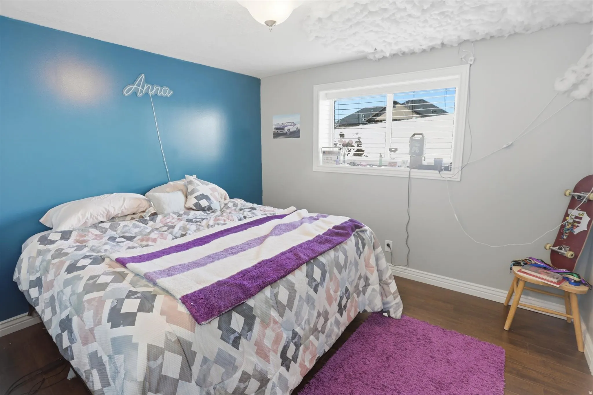 Bedroom with dark wood-style flooring and baseboards