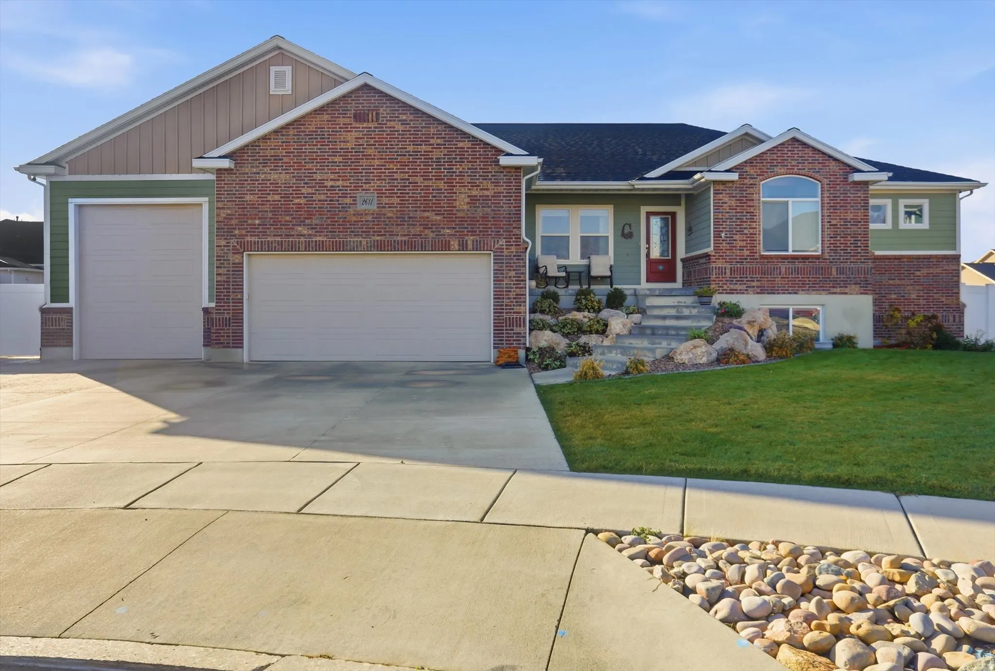 Ranch-style house featuring a front yard, a garage, concrete driveway, covered porch, and brick siding