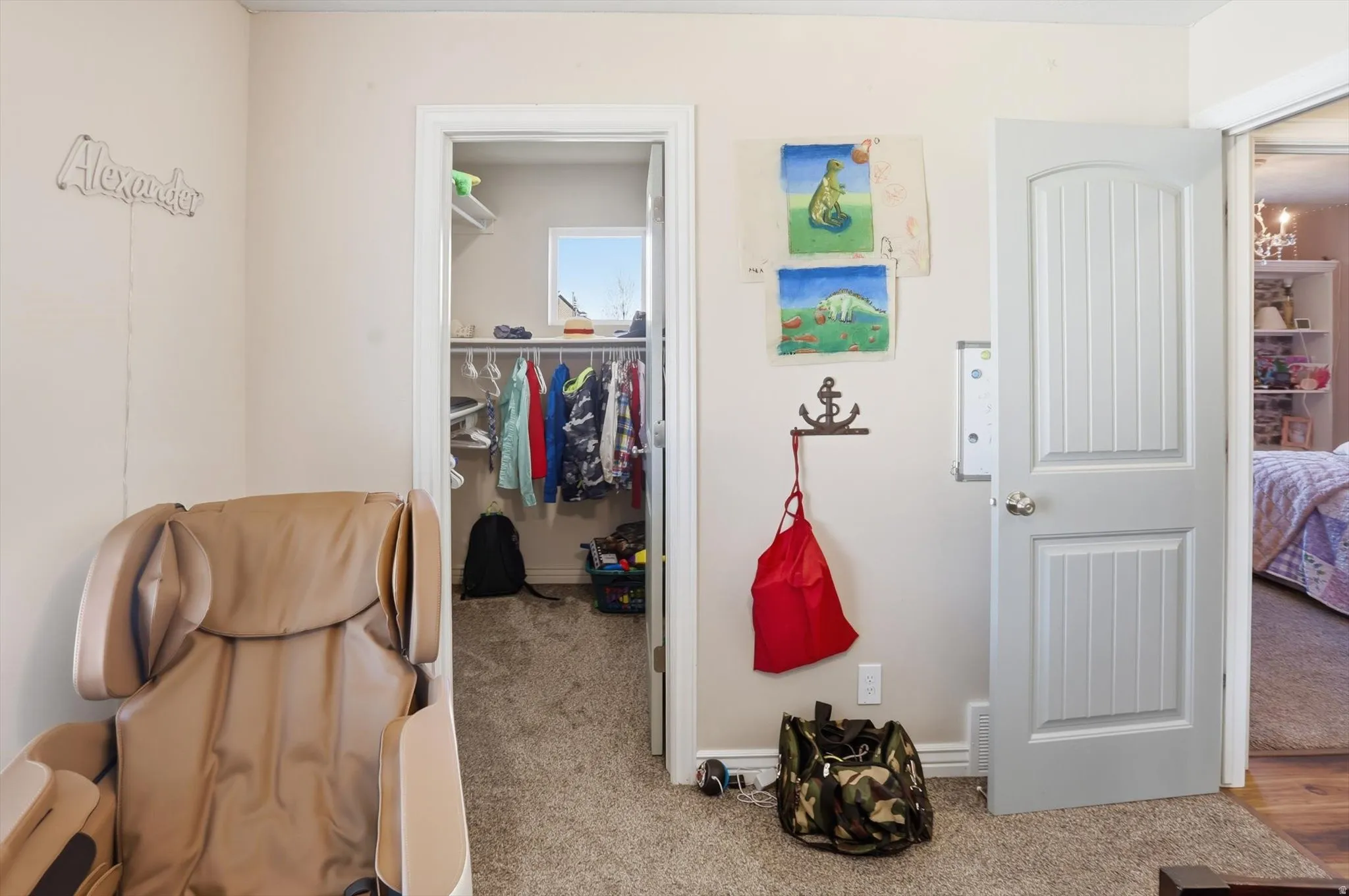 Bedroom with a walk in closet and light colored carpet