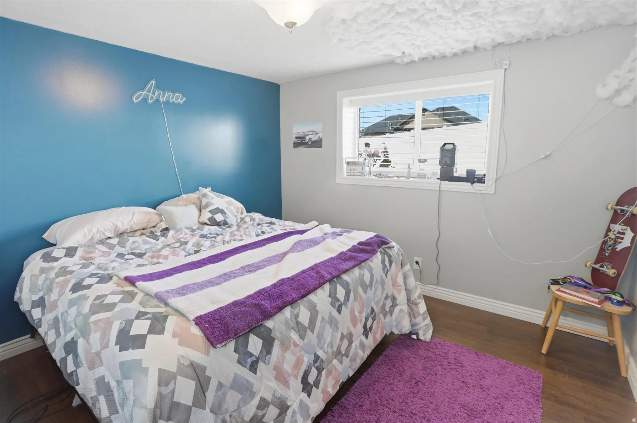 Bedroom with baseboards and dark wood-type flooring