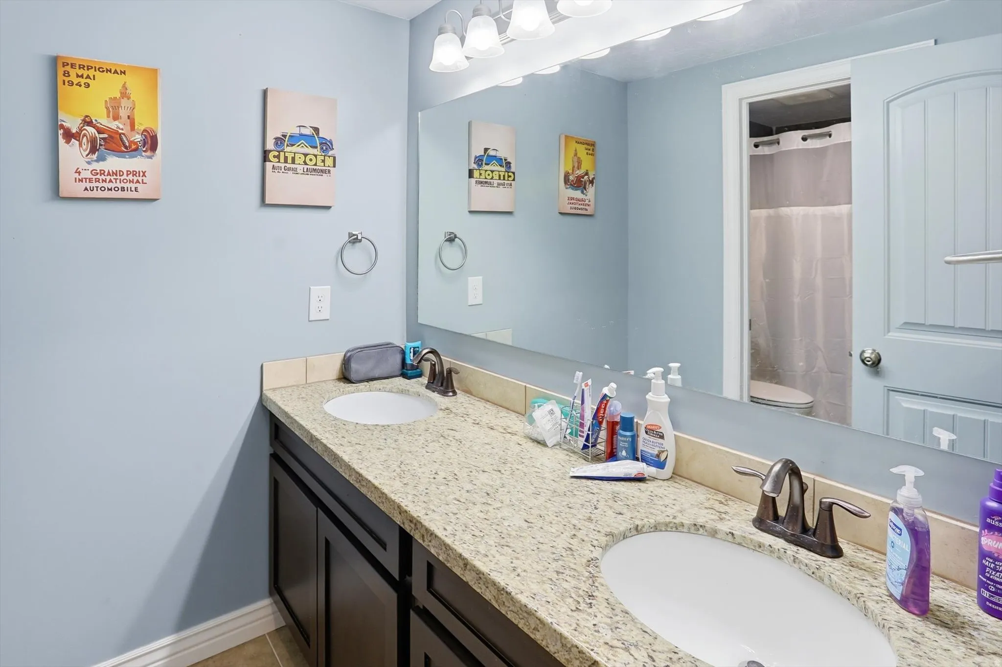 Bathroom featuring curtained shower and double vanity