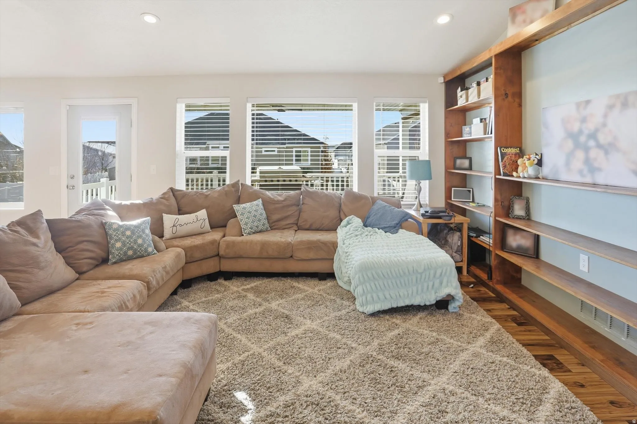 Living room with wood finished floors, healthy amount of natural light, and recessed lighting