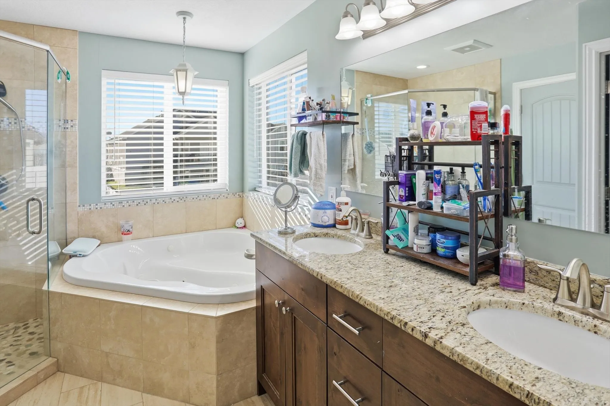 Full bath featuring double vanity, a bath, and a stall shower