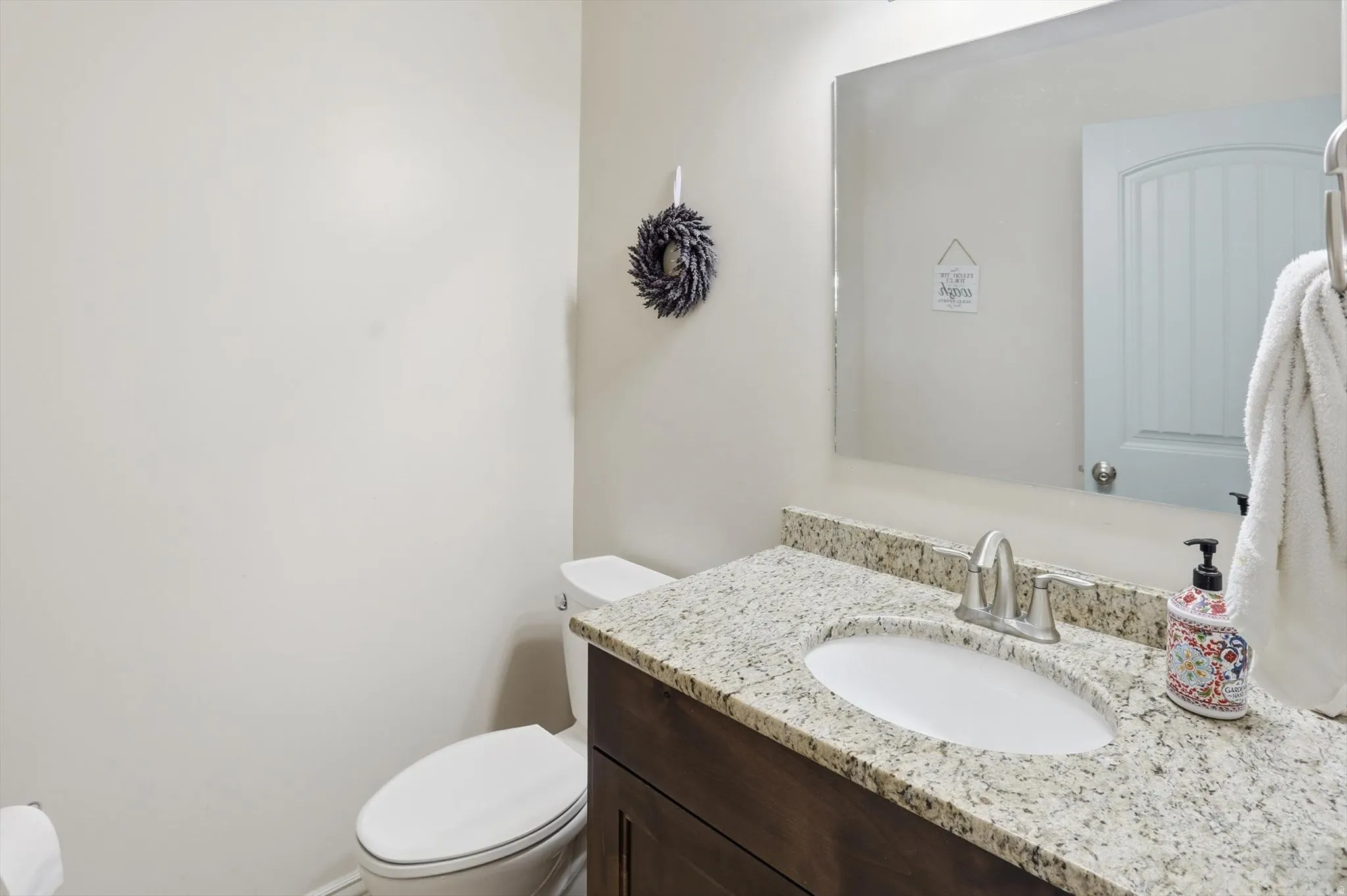 Half bathroom featuring vanity and toilet