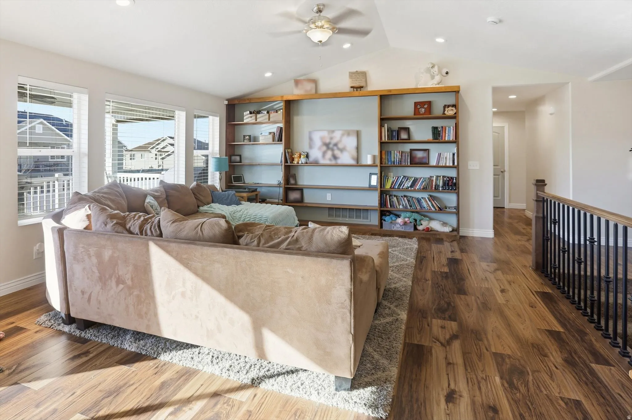 Living room featuring wood finished floors, ceiling fan, and lofted ceiling