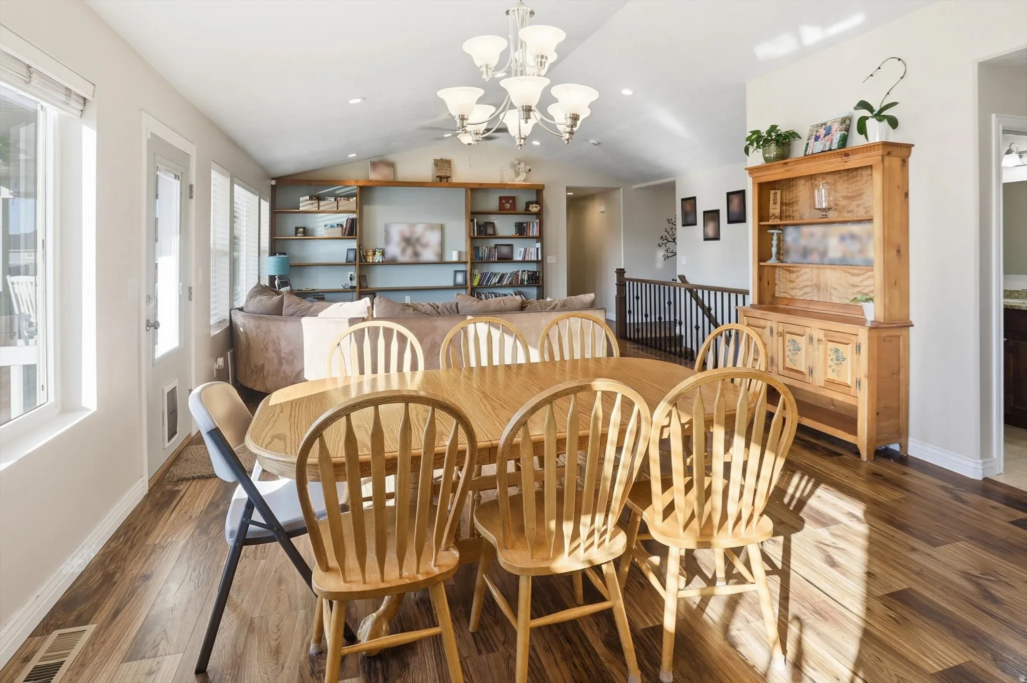 Dining room with vaulted ceiling, hardwood / wood-style floors, a chandelier, and recessed lighting