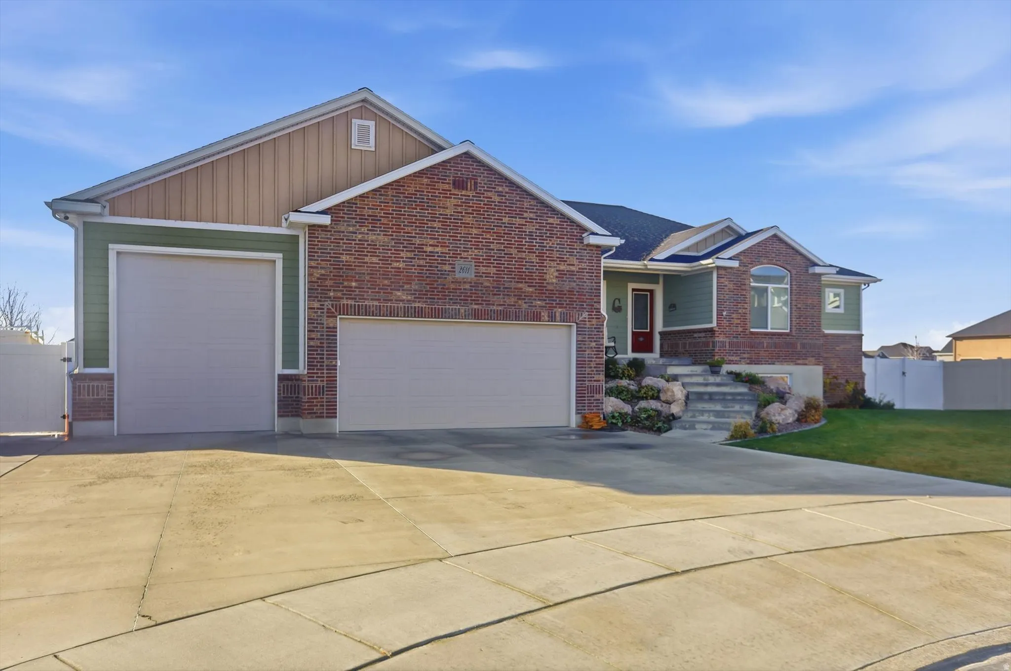 Single story home featuring concrete driveway, an attached garage, brick siding, and a porch