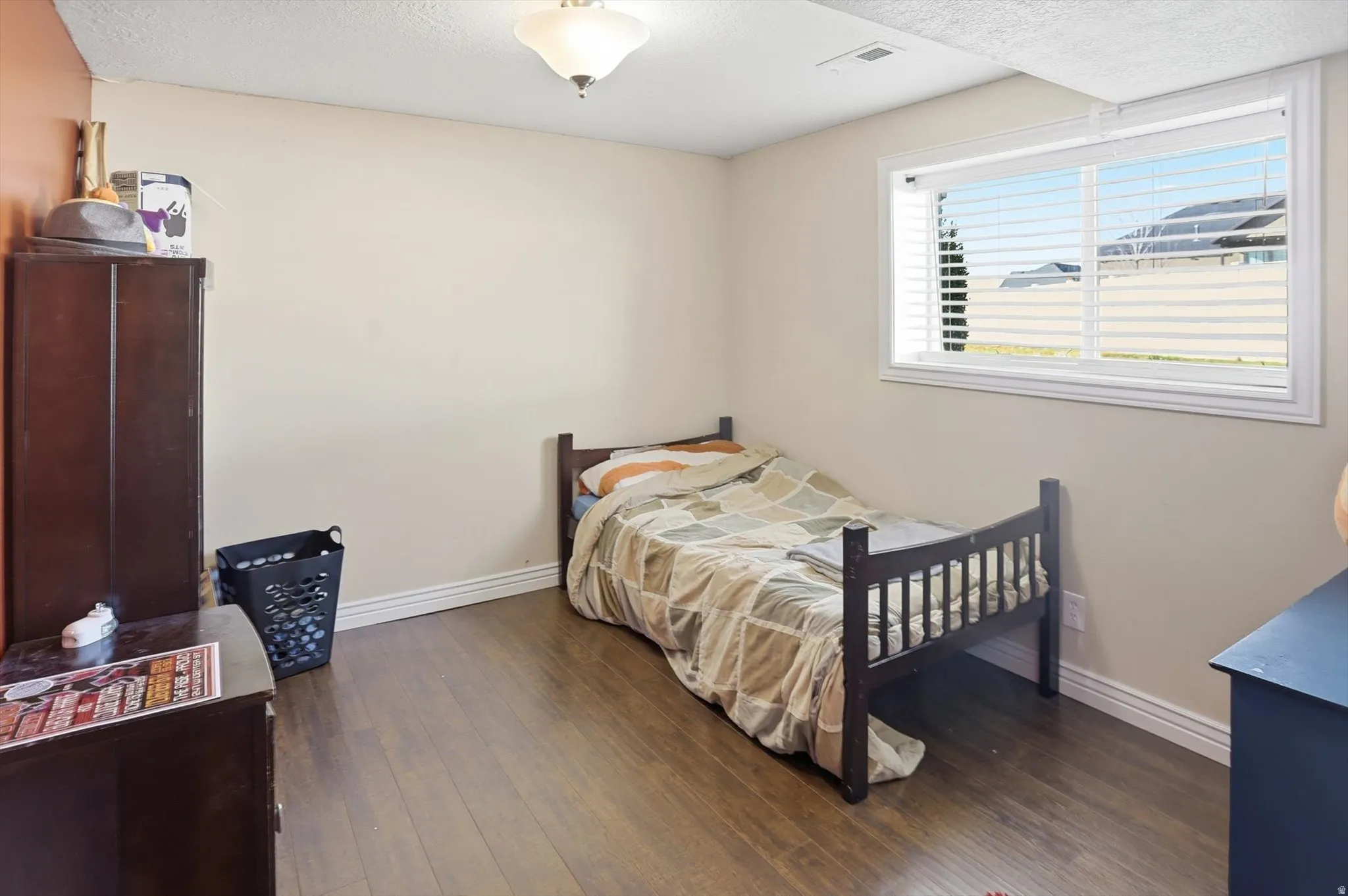 Bedroom featuring dark wood-type flooring and a textured ceiling