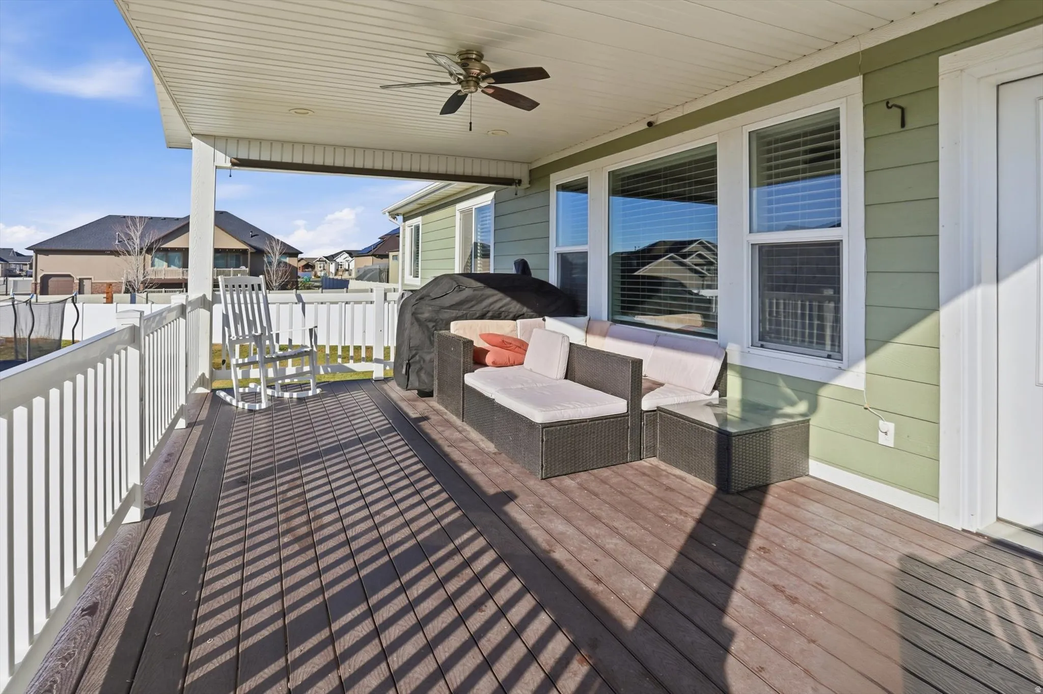 Deck featuring a ceiling fan, grilling area, an outdoor hangout area, and a residential view