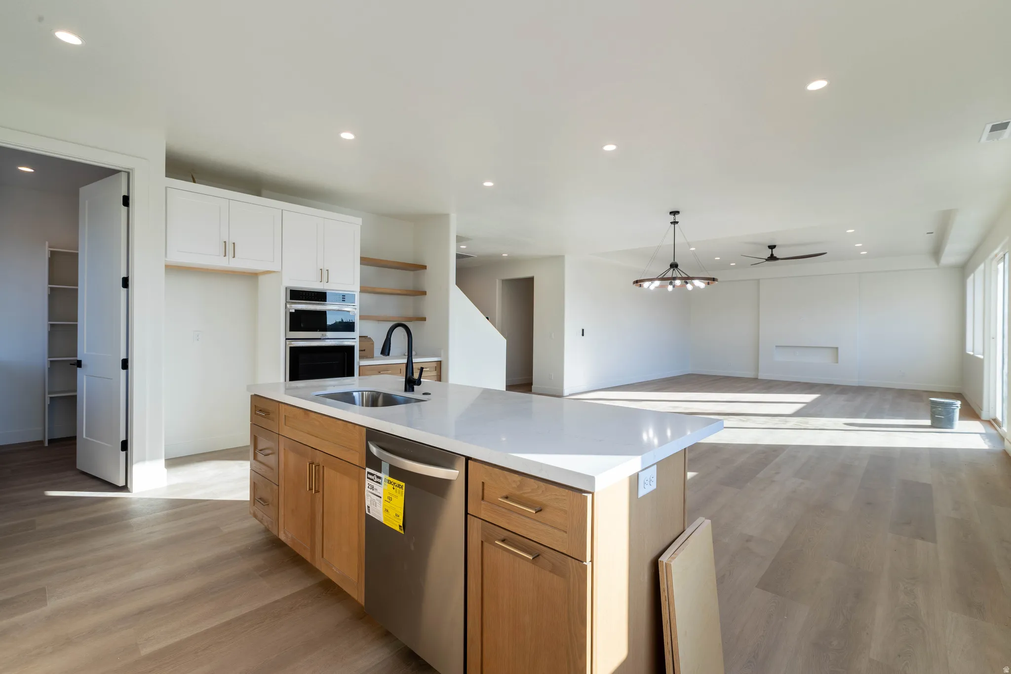 Kitchen featuring light wood-type flooring, recessed lighting, stainless steel appliances, open floor plan, and ceiling fan