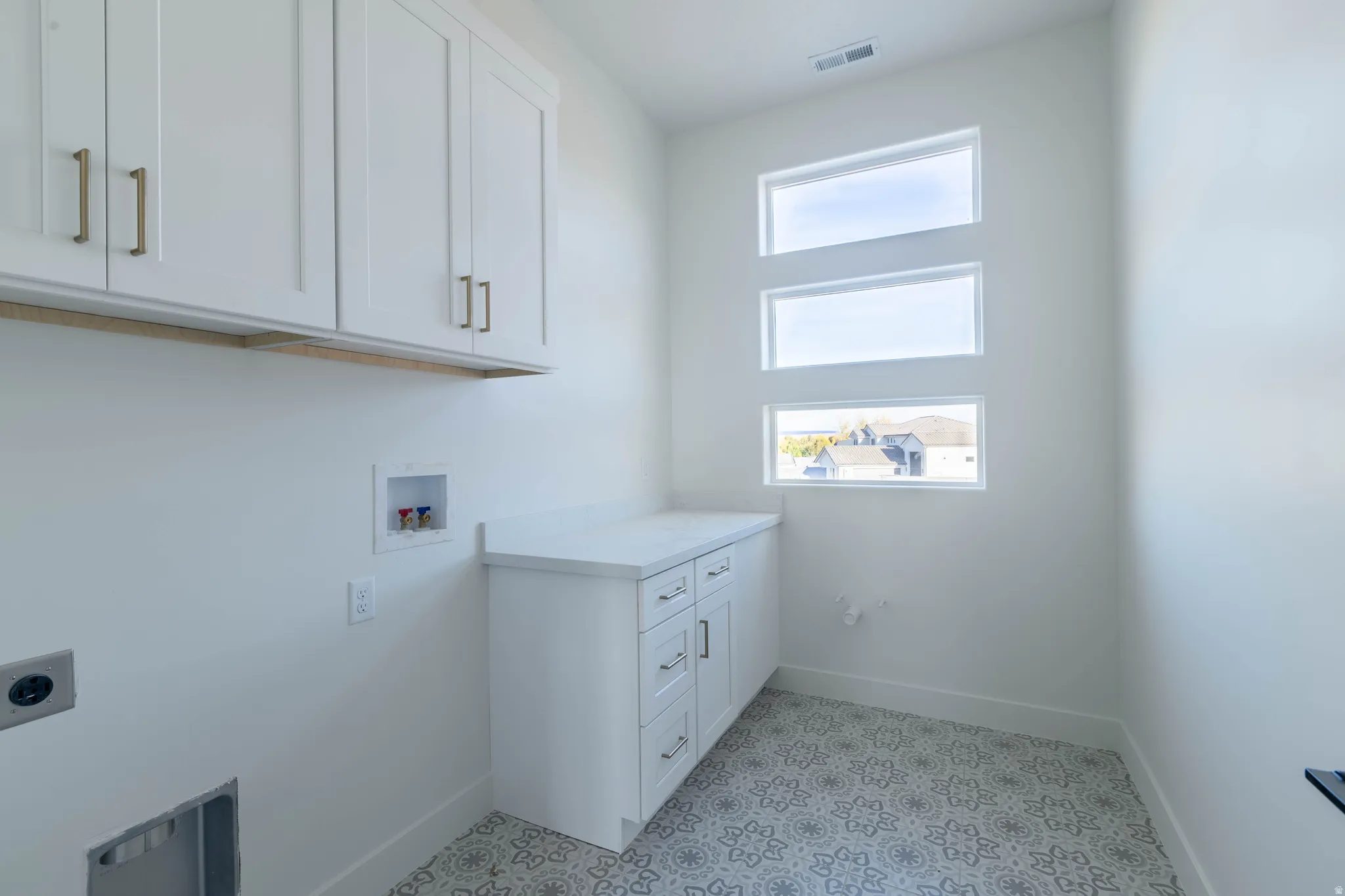 Laundry room featuring hookup for a washing machine, cabinet space, light floors, and electric dryer hookup