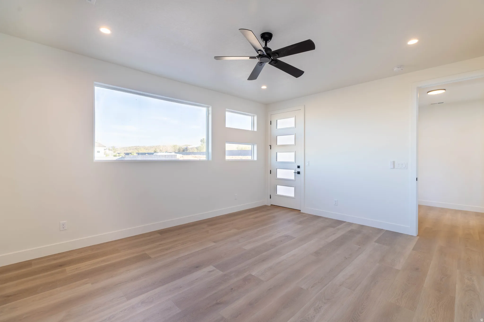 Unfurnished room with light wood-type flooring, a ceiling fan, and recessed lighting