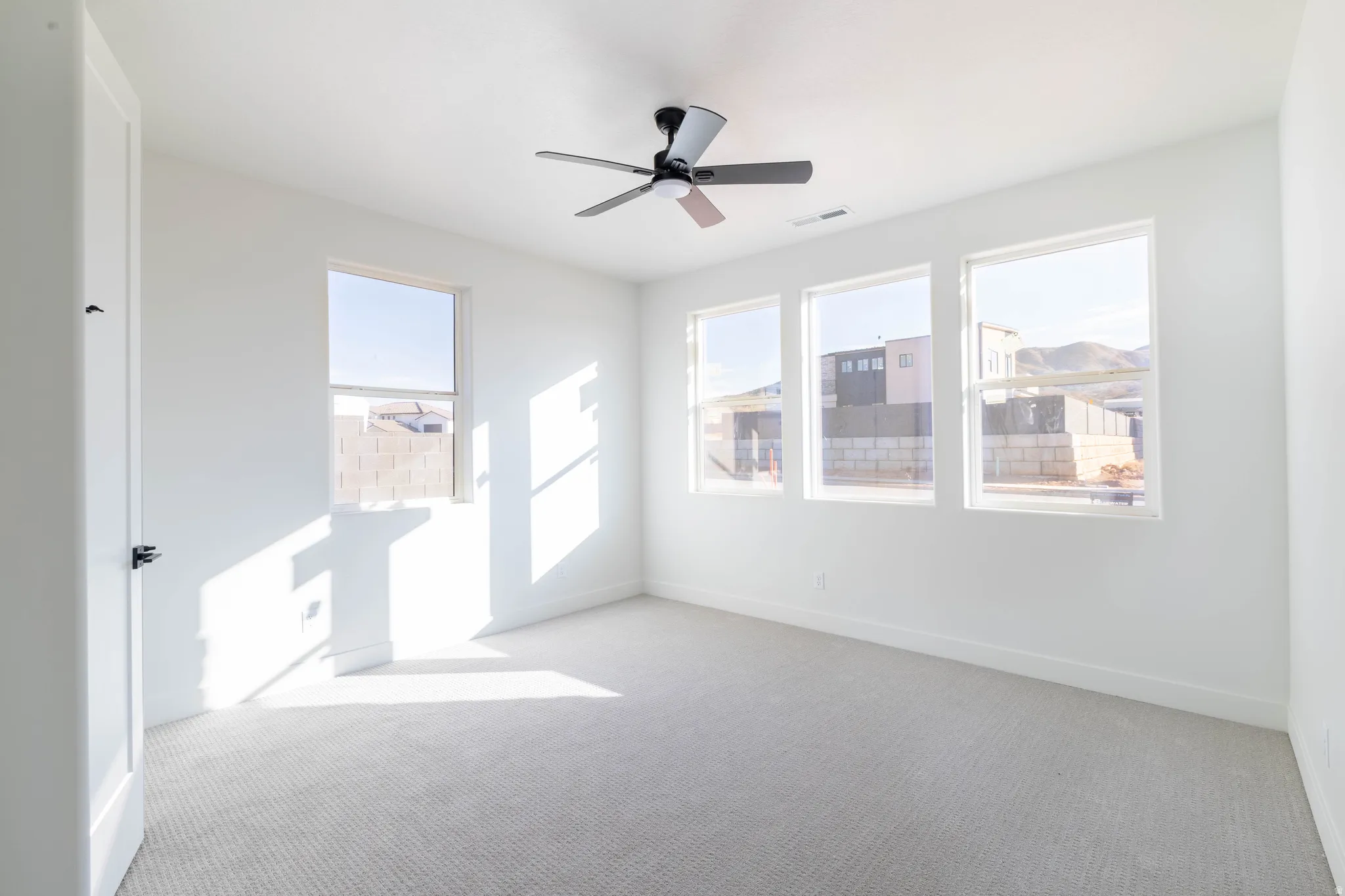 Empty room featuring carpet flooring and ceiling fan